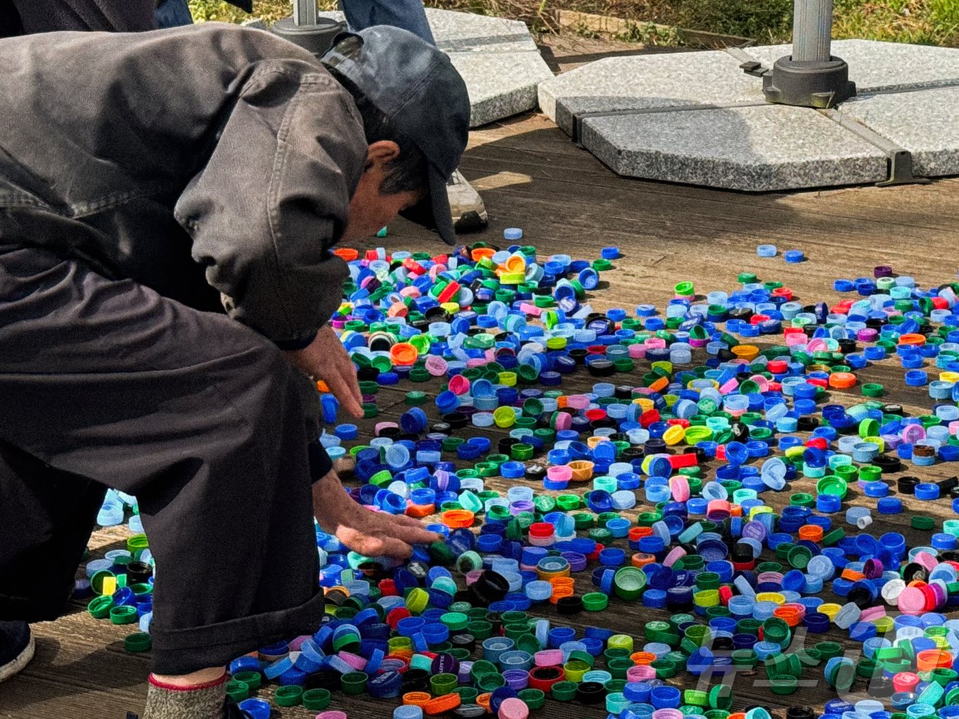 본문 이미지 - 제주시니어클럽 관계자가 활동가들이 수거해 온 플라스틱 병뚜껑들을 살펴보고 있다.(리어플라스틱 제공)