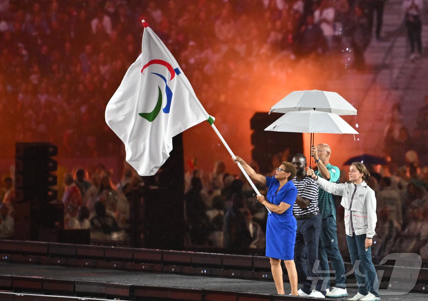 본문 이미지 - 9일(한국시간) 프랑스 생드니 스타드 드 프랑스에서 열린 2024 파리 패럴림픽 폐회식에서 2028 하계 패럴림픽의 개최 도시인 로스앤젤레스(LA) 캐런 배스 시장이 패럴림픽 깃발을 흔들고 있다. 2024.9.9/뉴스1 ⓒ News1 사진공동취재단