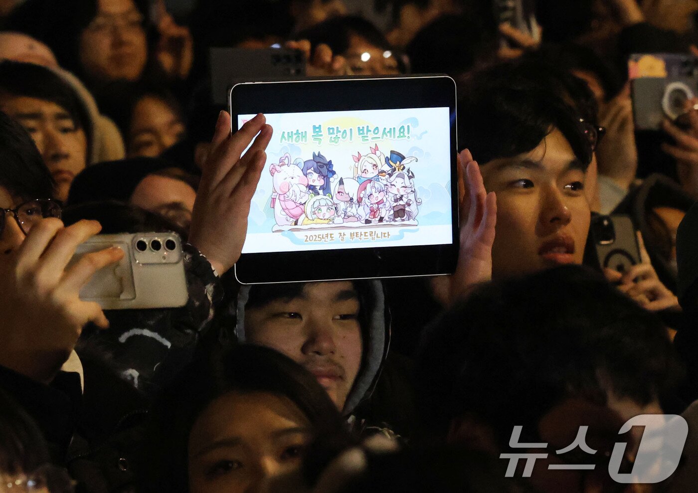 본문 이미지 - 을사년 새해 첫날인 1일 새벽 서울 종로구 보신각에서 열린 제야의 종 타종 행사에서 한 시민이 새해 소망 문구가 적힌 태블릿PC를 들고 있다. &#40;공동취재&#41;2025.1.1/뉴스1 ⓒ News1 박세연 기자