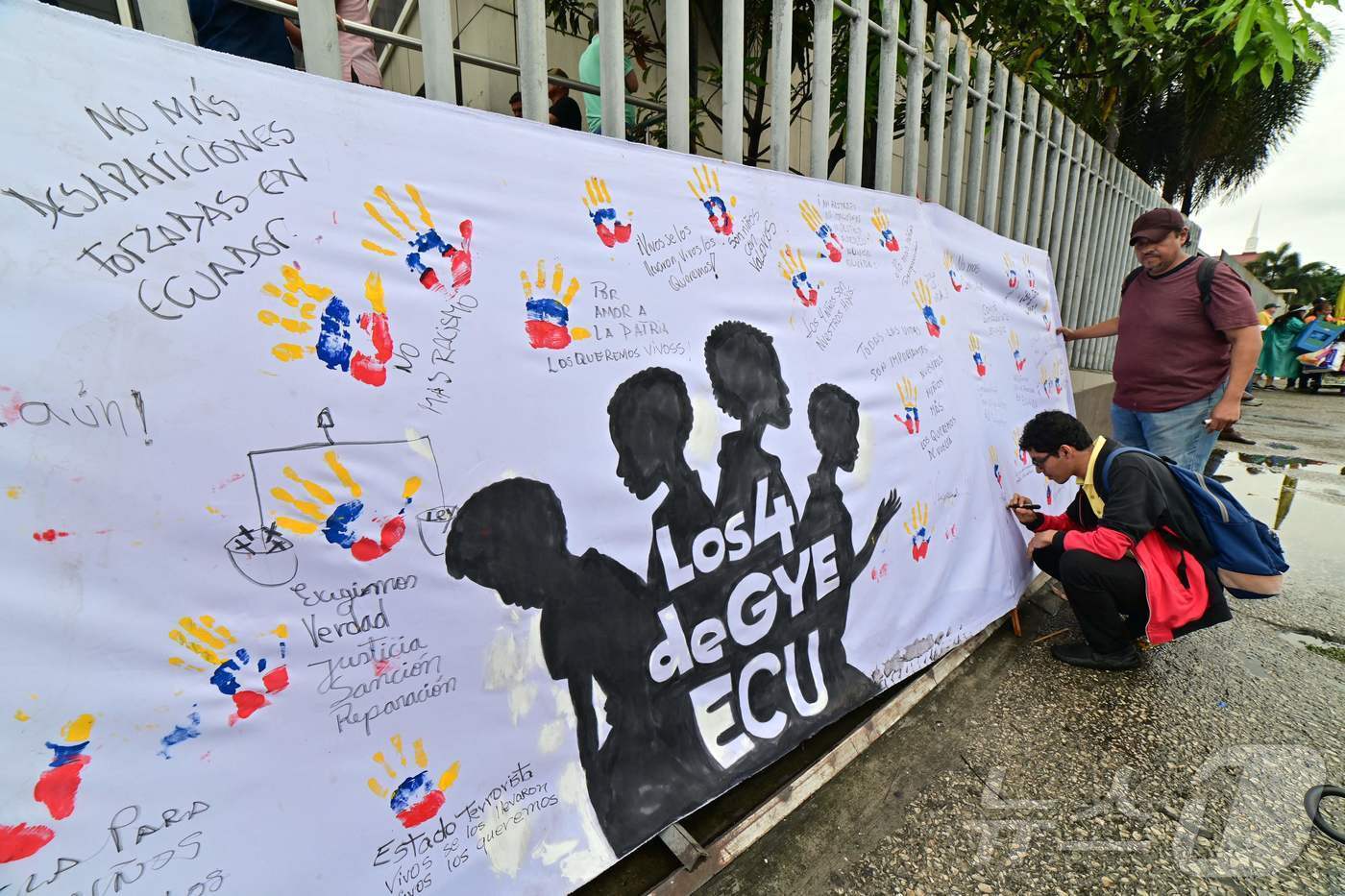 본문 이미지 - 2024년 12월 31일 에콰도르 과야킬 법원에서 실종에 연루된 것으로 추정되는 군인 16명에 대한 공판 심리가 진행되는 동안 밖에서는 시민들이 소년들 4명을 애도하는 글을 적고 있다. ⓒ AFP=뉴스1
