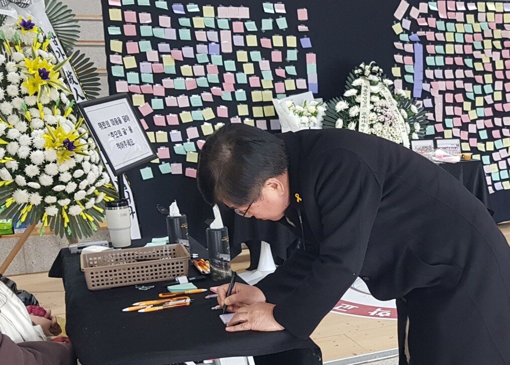 본문 이미지 - 무안 제주항공 참사에서 희생된 세종장영실고 두 자매 분향소에서 최교진 세종시교육감이 방명록을 적고 있다. / 뉴스1