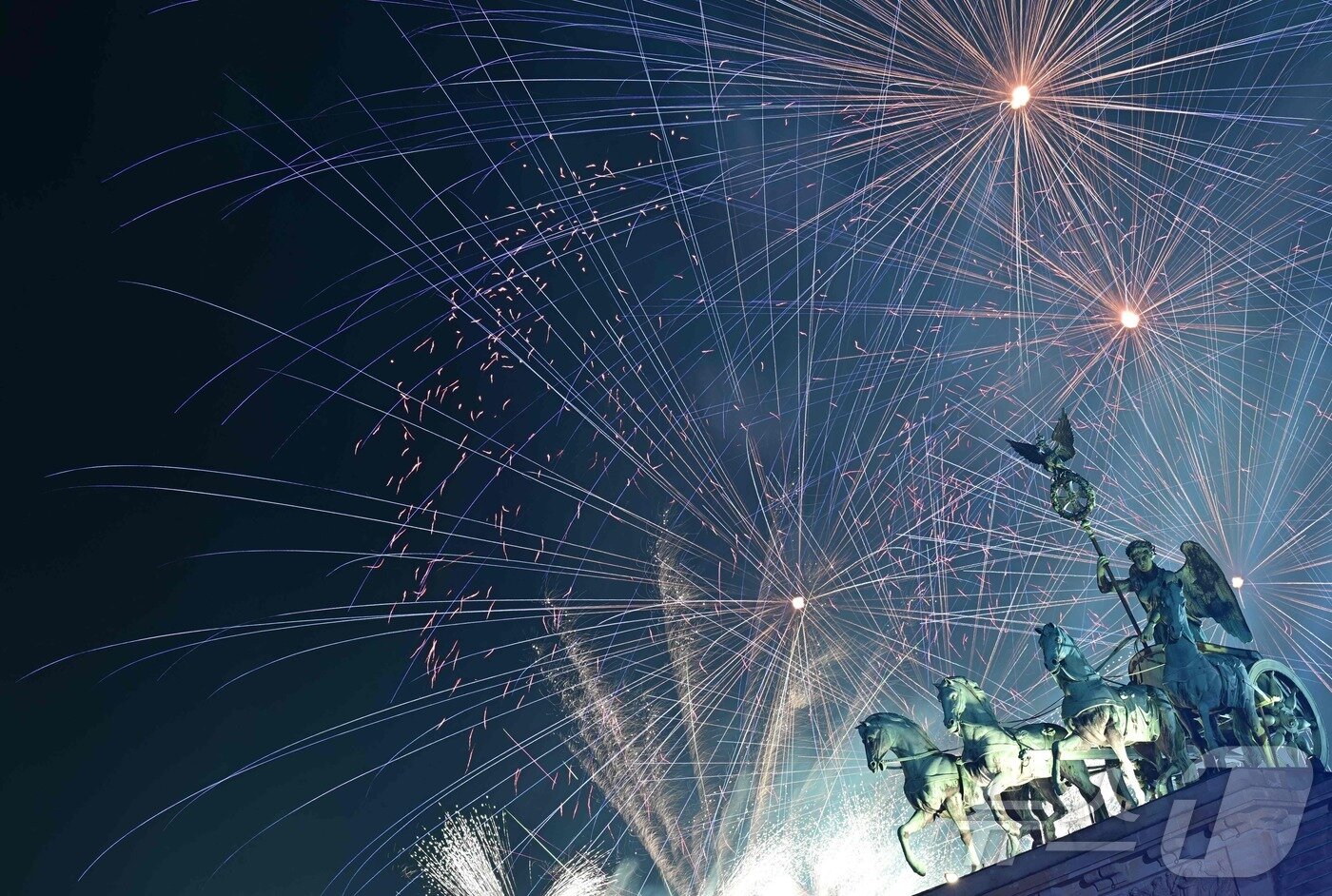 본문 이미지 - 독일 수도 베를린의 브란덴베르크 문의 전차 콰드리가 동상 위로 2025년 새해 맞이 불꽃놀이가 밤하늘을 수놓고 있다. 2025.1.1 ⓒ AFP=뉴스1 ⓒ News1 강민경 기자