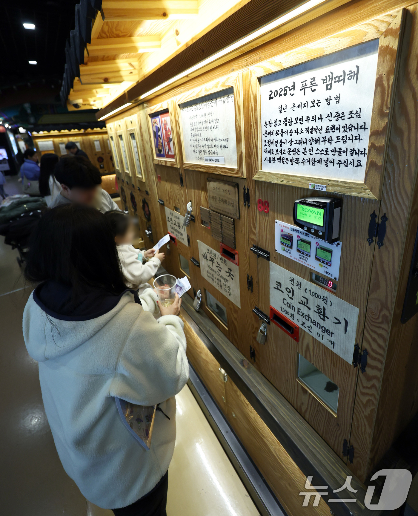 (서울=뉴스1) 구윤성 기자 = 1일 서울 송파구 롯데월드 민속박물관 저자거리에서 시민들이 을사년 새해를 맞아 신년운세를 보고 있다. 2025.1.1/뉴스1