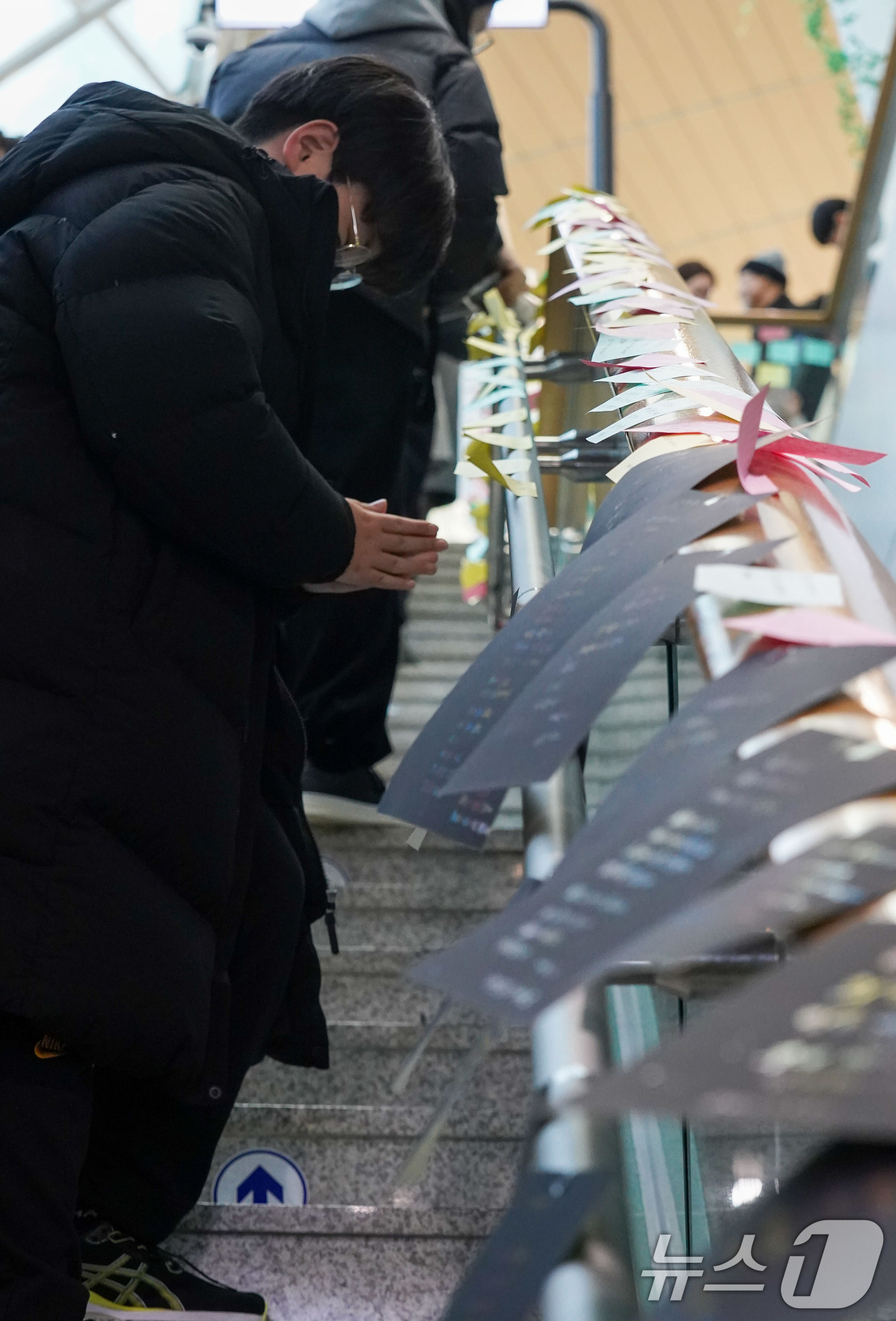 (무안=뉴스1) 김민지 기자 = 제주항공 여객기 참사 나흘째인 1일 전남 무안국제공항 여객터미널 1층 계단에서 한 어린이가 기도하고 있다. (공동취재) 2025.1.1/뉴스1
