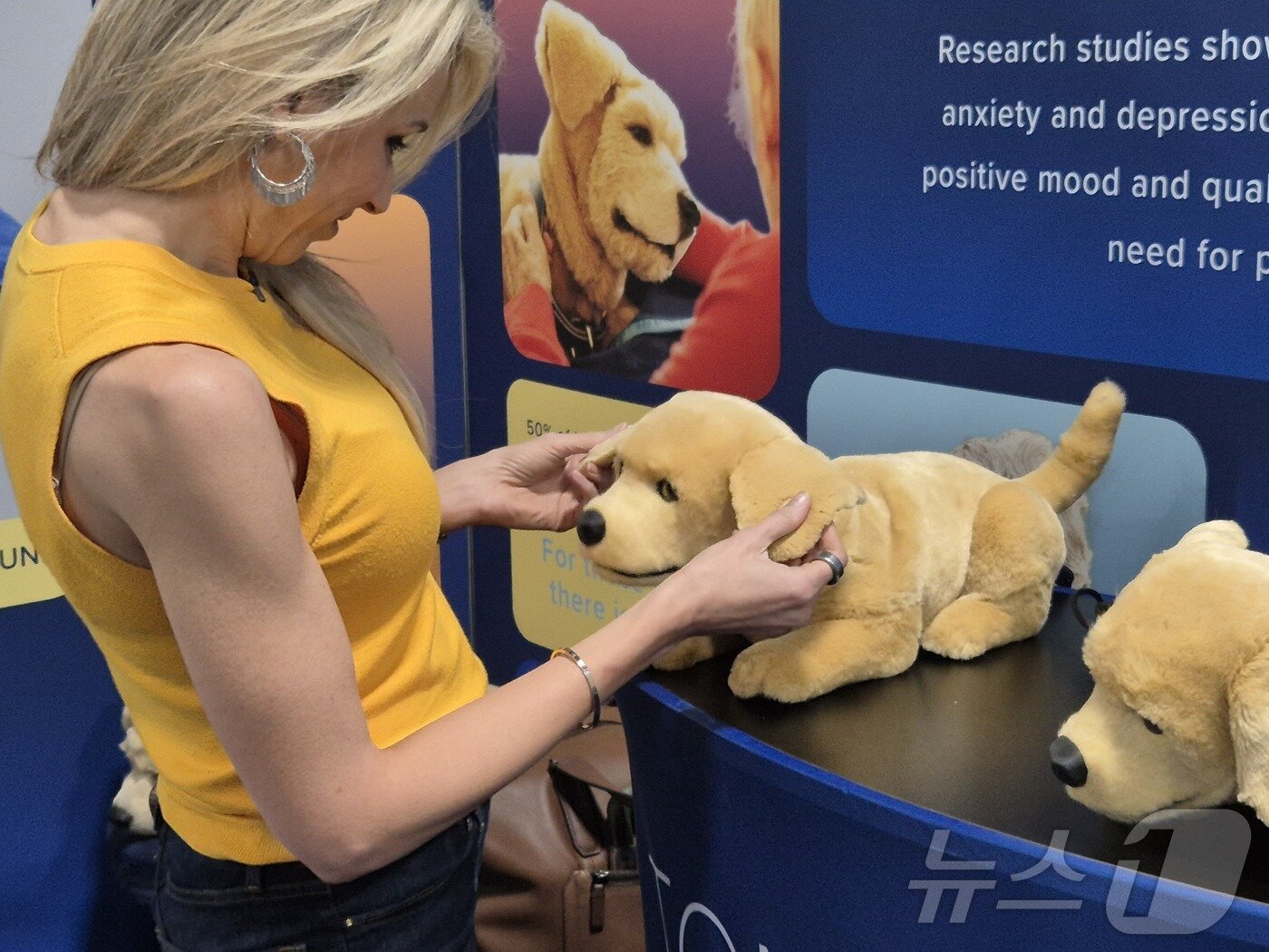 본문 이미지 - 미국 라스베이거스에서 열린 세계 최대 정보기술(IT)·가전 전시회 'CES 2025' 베네치안 엑스포에 참가한 관람객이 미국 스타트업 톰봇이 개발한 AI 반려견 '제니'를 만져보고 있다.2025.1.8/뉴스1 최동현 기자