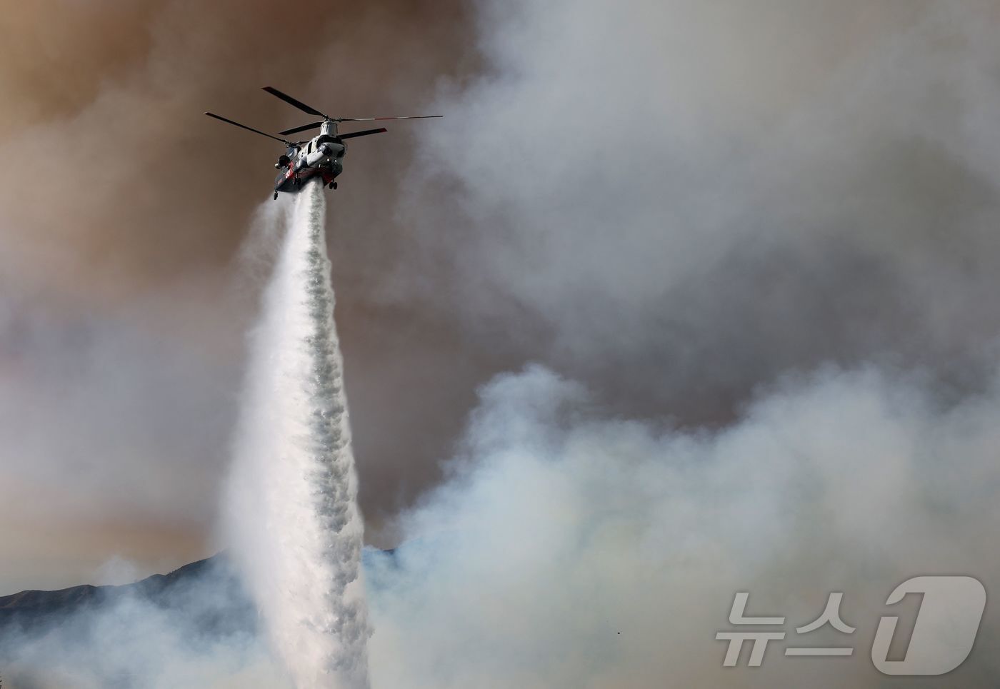 본문 이미지 - 11일 &#40;현지시간&#41; 팰리세이즈 파이어가 발생한 캘리포니아주 로스앤젤레스에서 소방 헬기가 진화 작업을 하고 있다. 202.01,12 ⓒ AFP=뉴스1 ⓒ News1 우동명 기자