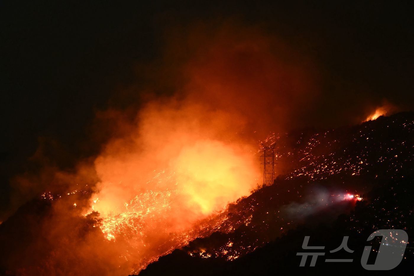 본문 이미지 - 11일 &#40;현지시간&#41; 팰리세이즈 파이어가 발생한 캘리포니아주 로스앤젤레스 인근 엔치노의 언덕에서 화염이 솟아 오르고 있다. 202.01,12 ⓒ AFP=뉴스1 ⓒ News1 우동명 기자