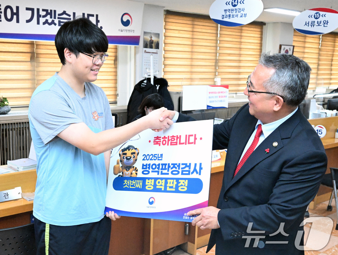 (서울=뉴스1) 박세연 기자 = 새해 첫 병역판정검사가 실시된 13일 서울 영등포 서울지방병무청에서 현역 판정을 받은 입영대상자가 김종철 병무청장에게 축하 인사를 받고 있다. (공 …