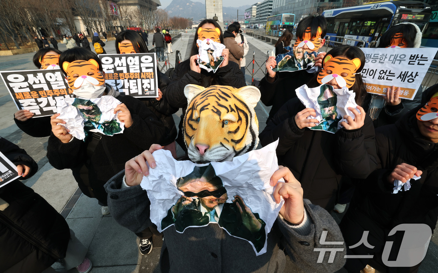 (서울=뉴스1) 임세영 기자 = 13일 오전 서울 세종대로 광화문광장에서 열린 '윤석열 물어가는 범청년행동 출범 기자회견'에서 참석자들이 호랑이 가면을 쓰고 윤석열 대통령 사진을 …