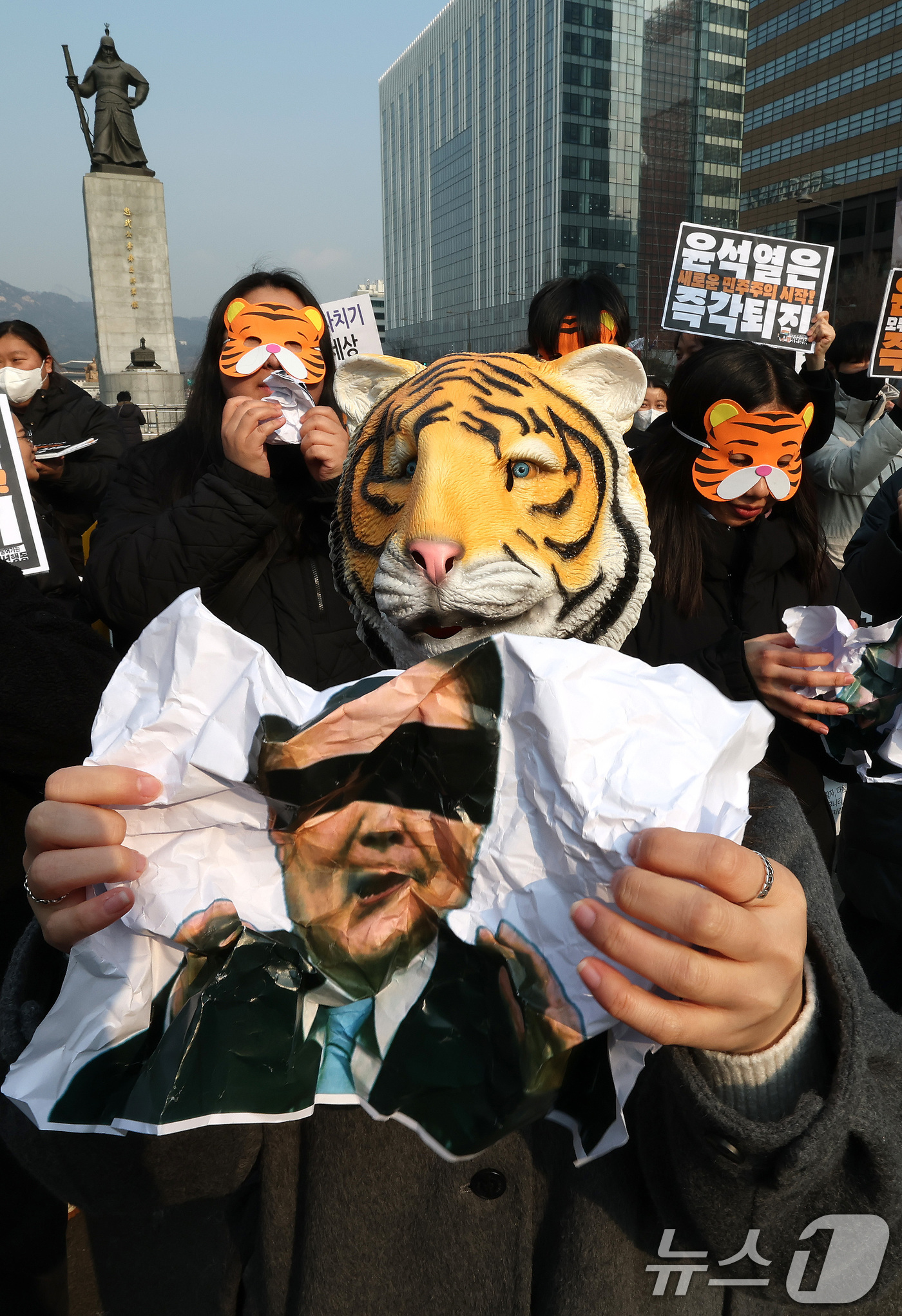 (서울=뉴스1) 임세영 기자 = 13일 오전 서울 세종대로 광화문광장에서 열린 '윤석열 물어가는 범청년행동 출범 기자회견'에서 참석자들이 호랑이 가면을 쓰고 윤석열 대통령 사진을 …