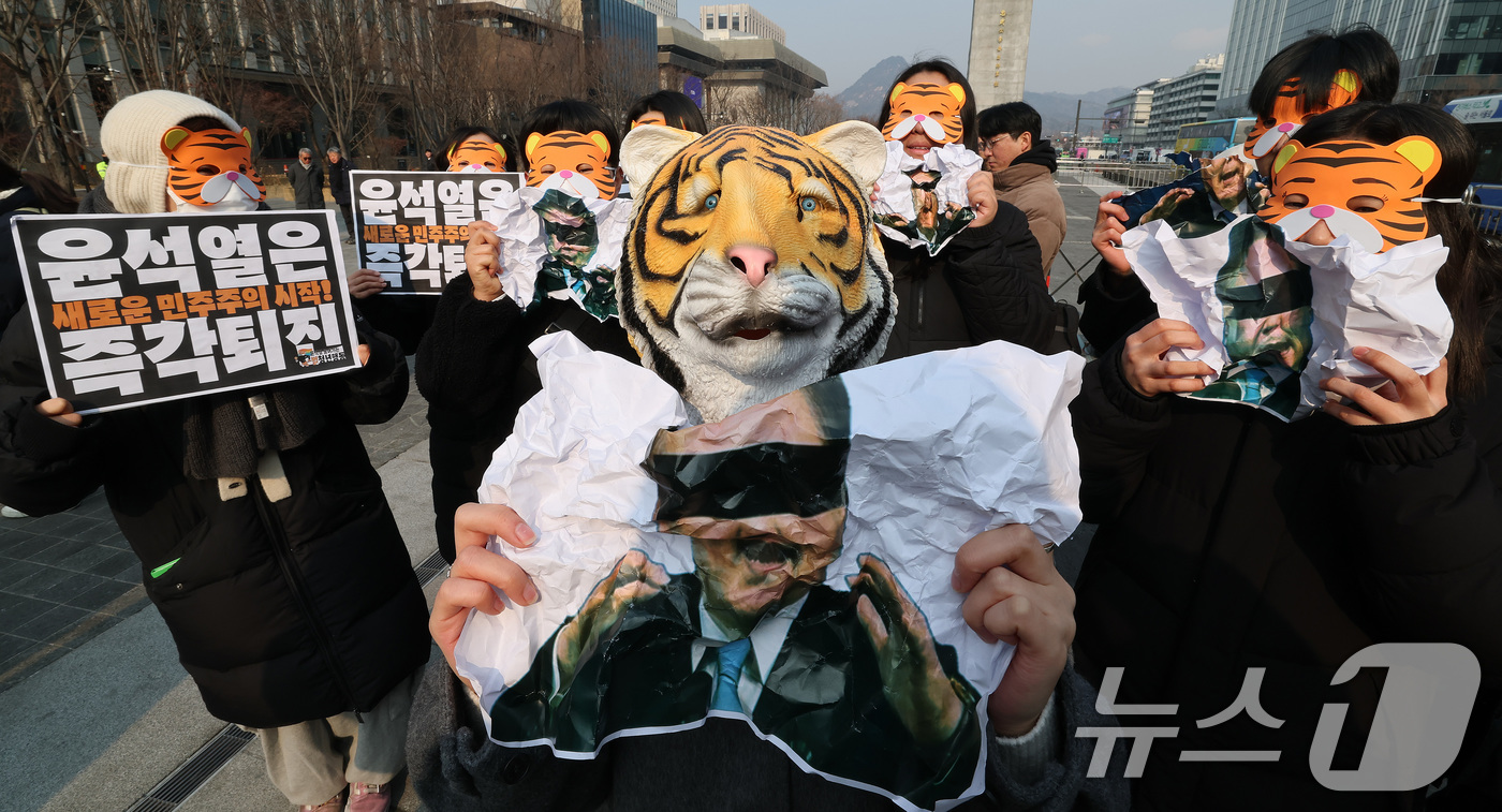 (서울=뉴스1) 임세영 기자 = 13일 오전 서울 세종대로 광화문광장에서 열린 '윤석열 물어가는 범청년행동 출범 기자회견'에서 참석자들이 호랑이 가면을 쓰고 윤석열 대통령 사진을 …