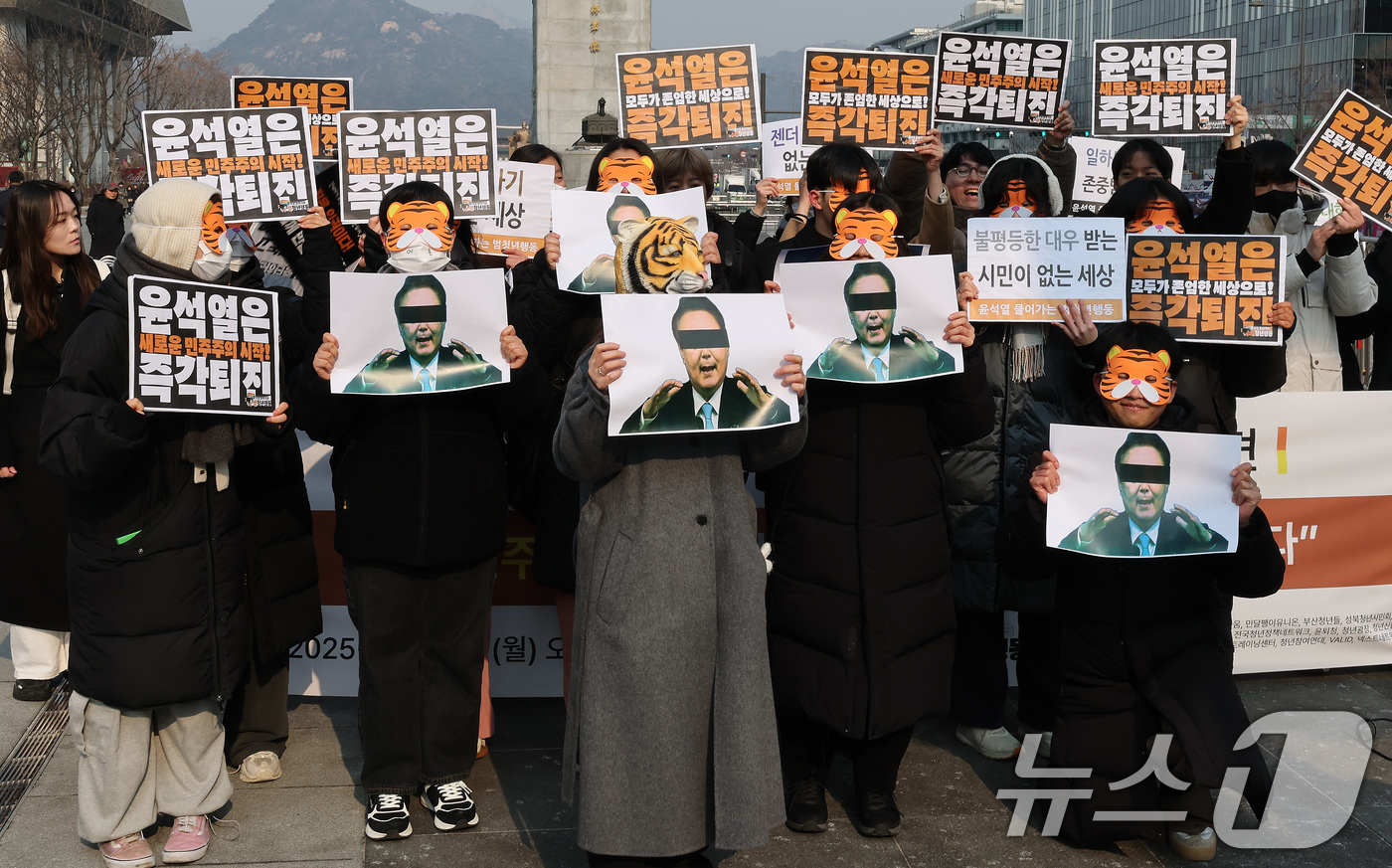 (서울=뉴스1) 임세영 기자 = 13일 오전 서울 세종대로 광화문광장에서 열린 '윤석열 물어가는 범청년행동 출범 기자회견'에서 참석자들이 호랑이 가면을 쓰고 윤석열 대통령 사진을 …