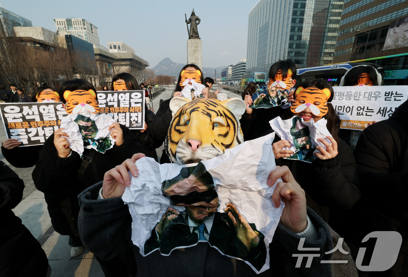 (서울=뉴스1) 임세영 기자 = 13일 오전 서울 세종대로 광화문광장에서 열린 '윤석열 물어가는 범청년행동 출범 기자회견'에서 참석자들이 호랑이 가면을 쓰고 윤석열 대통령 사진을 …