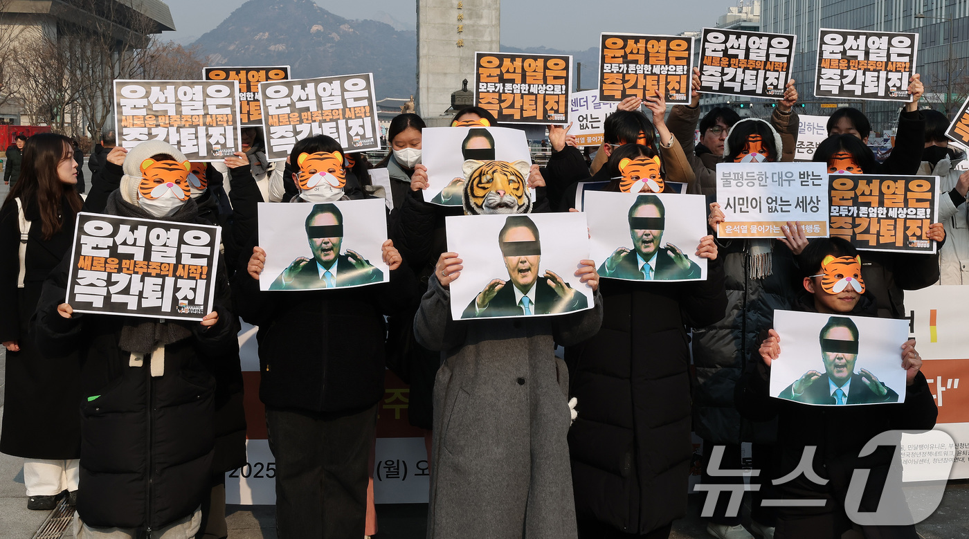 (서울=뉴스1) 임세영 기자 = 13일 오전 서울 세종대로 광화문광장에서 열린 '윤석열 물어가는 범청년행동 출범 기자회견'에서 참석자들이 호랑이 가면을 쓰고 윤석열 대통령 사진을 …