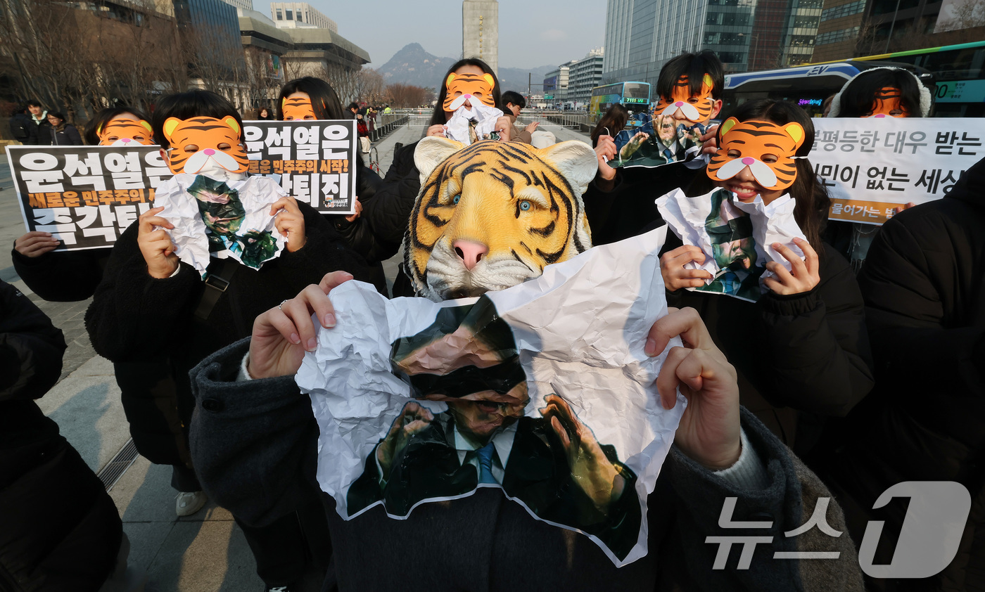 (서울=뉴스1) 임세영 기자 = 13일 오전 서울 세종대로 광화문광장에서 열린 '윤석열 물어가는 범청년행동 출범 기자회견'에서 참석자들이 호랑이 가면을 쓰고 윤석열 대통령 사진을 …