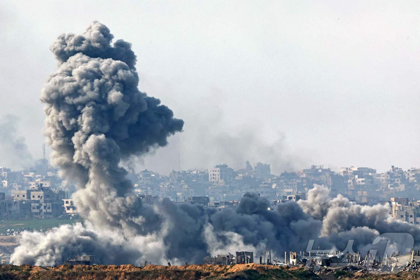 본문 이미지 - 14일 &#40;현지시간&#41; 팔레스타인 가자 지구 북부의 파괴된 빌딩 위에서 이스라엘 군의 포격으로 연기 기둥이 솟아 오르고 있다. 2025.01.15 ⓒ AFP=뉴스1 ⓒ News1 우동명 기자