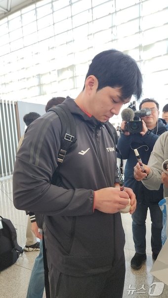 본문 이미지 - 15일 인천공항서 출국에 앞서 팬들에게 사인해주고 있는 오지환. ⓒ News1 이재상기자