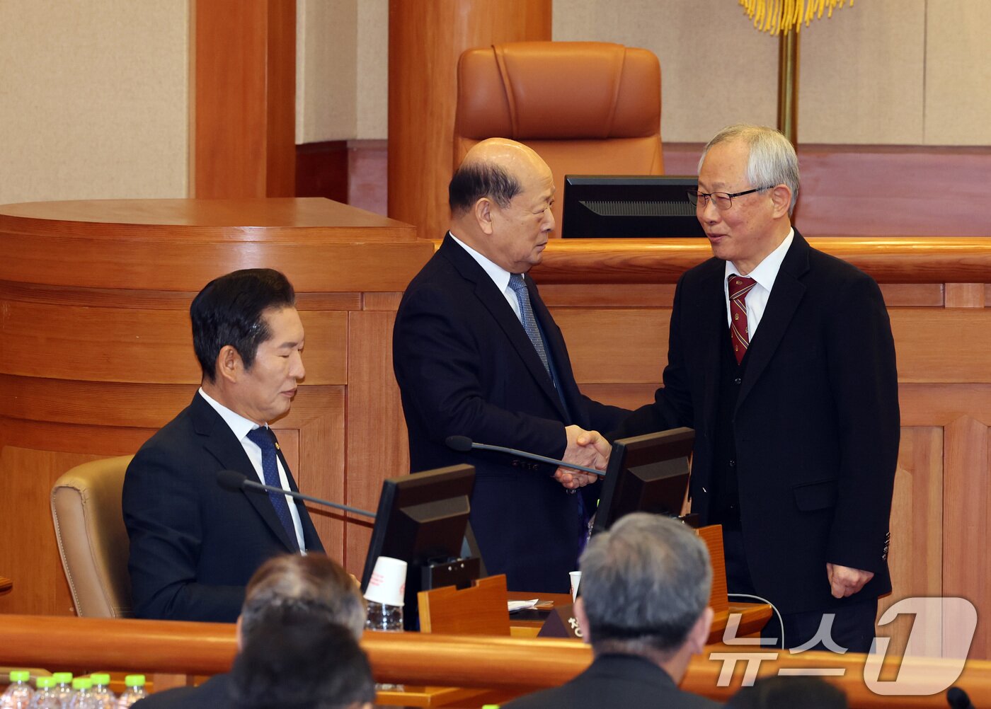 본문 이미지 - 윤석열 대통령 탄핵심판 2차 변론기일이 진행된 16일 오후 서울 종로구 헌법재판소 심판정에서 조대현 피청구인 법률대리인(오른쪽)과 송두환 탄핵소추 법률대리인(왼쪽 둘째)이 악수하고 있다. 왼쪽은 정청래 국회 탄핵소추단장. (공동취재) 2025.1.16/뉴스1 ⓒ News1 황기선 기자