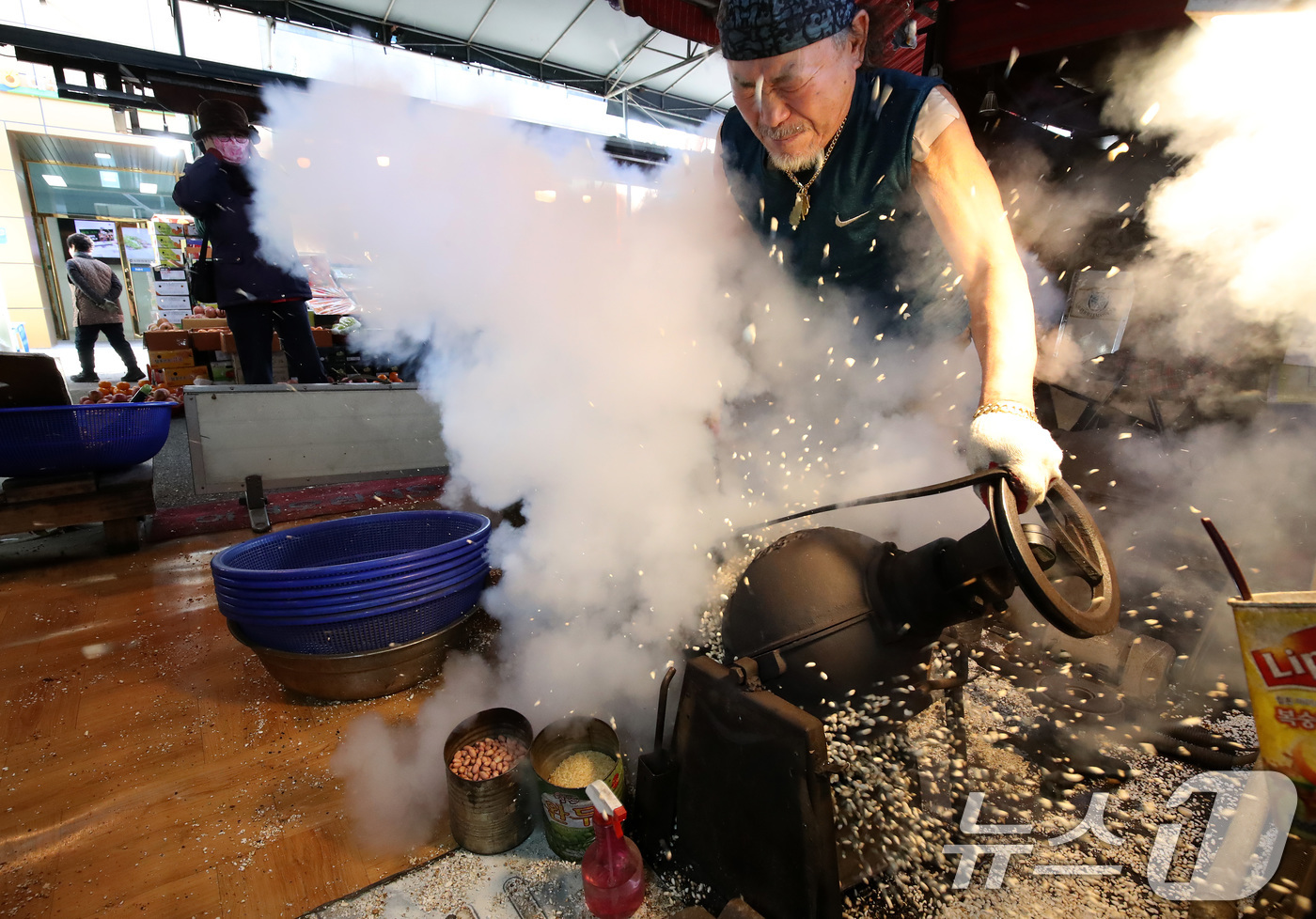 (대구=뉴스1) 공정식 기자 = 설을 앞두고 17일 오후 대구 중구 번개시장에서 뻥튀기 가게 주인이 쌀·콩·누룽지 등 강정 재료를 '뻥' 소리와 함께 튀겨내고 있다. 2025.1. …