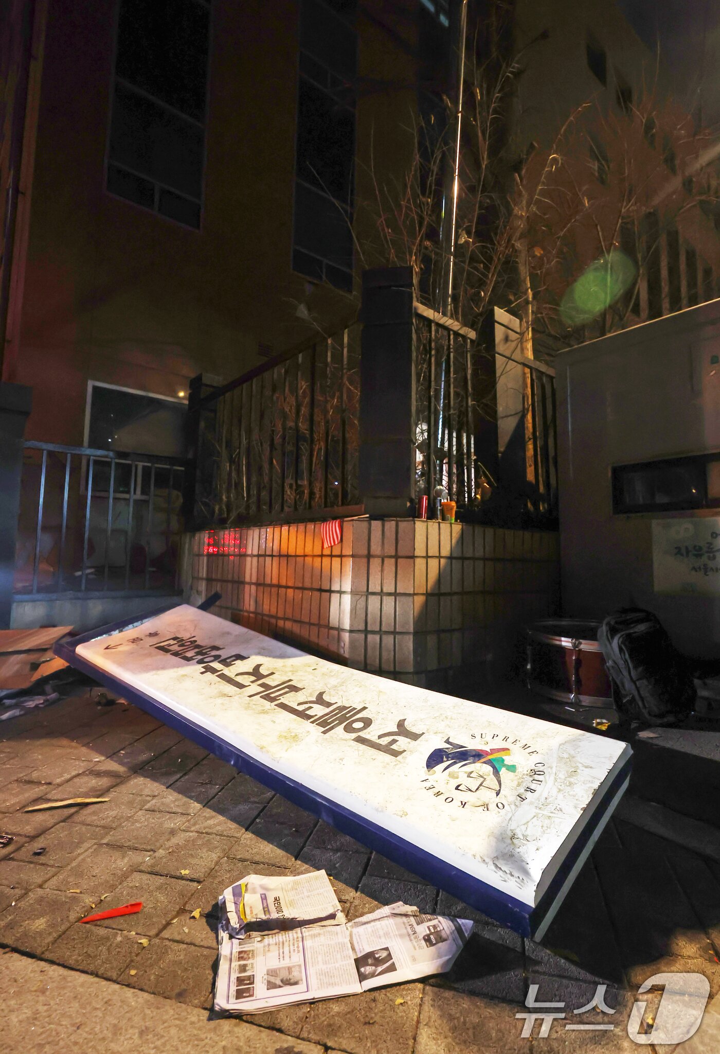 본문 이미지 - 19일 새벽 서울 마포구 서울서부지방법원에 윤석열 대통령에 대한 구속영장 발부 소식에 격분한 윤 대통령 지지자들이 난입해 법원 현판을 훼손시켜 땅에 떨어져 있다. 2025.1.19/뉴스1 ⓒ News1 민경석 기자