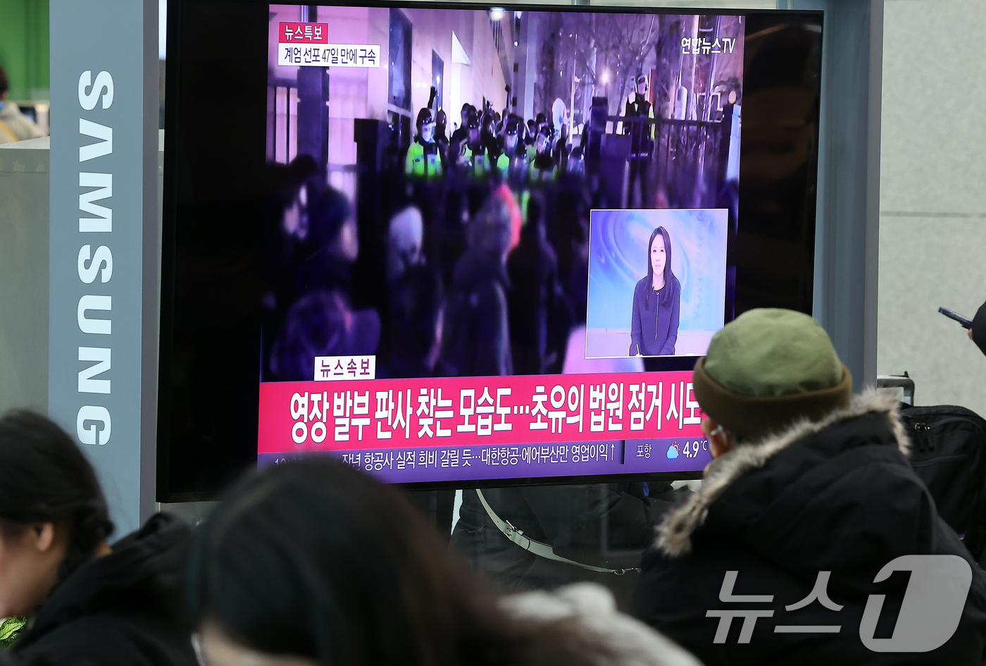 (인천공항=뉴스1) 김진환 기자 = 내란 우두머리 혐의를 받는 윤석열 대통령이 구속된 19일 오전 인천국제공항 제1터미널 입국장 텔레비전으로 관련 속보가 생중계 되고 있다.윤 대통 …