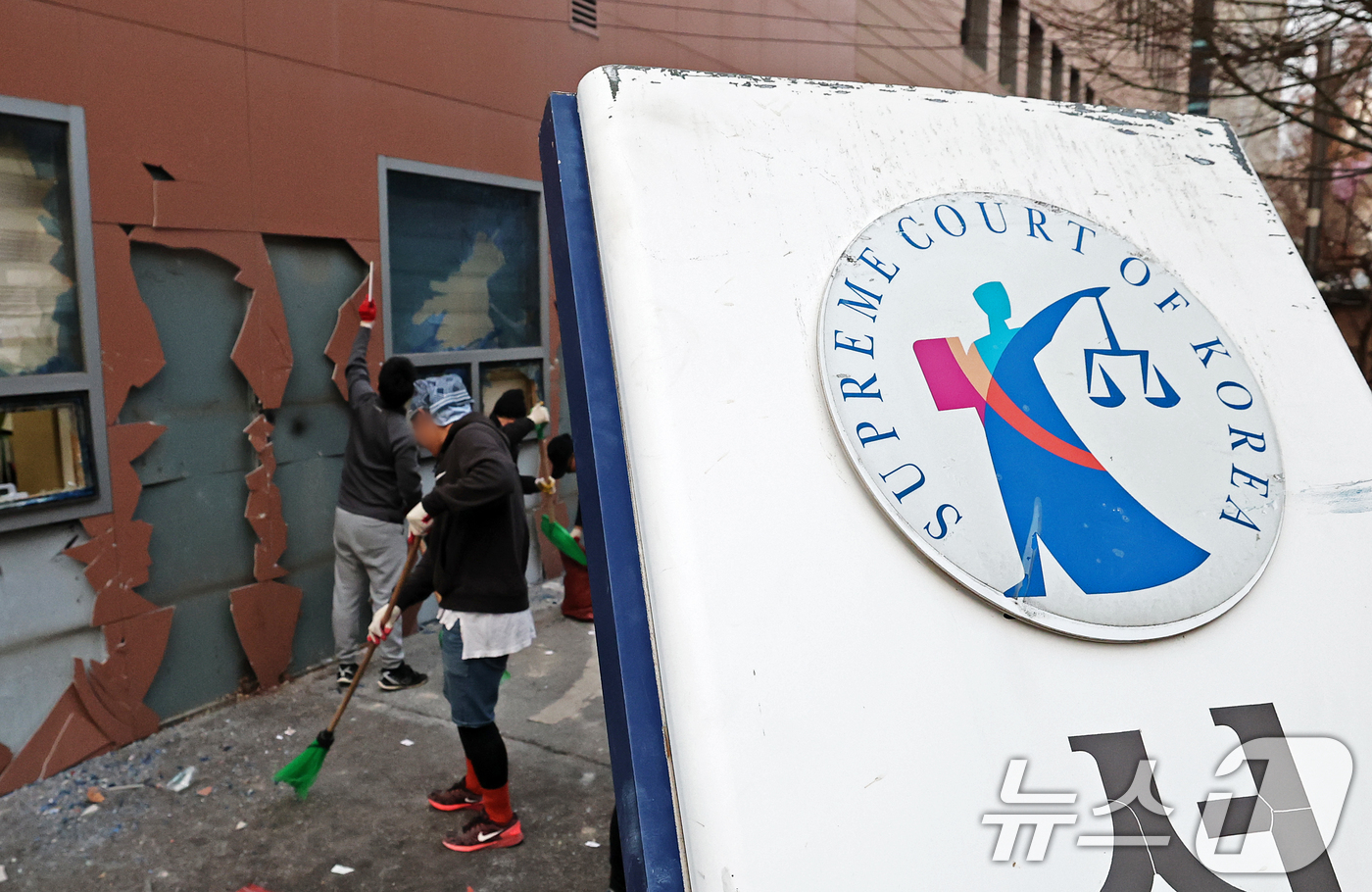 (서울=뉴스1) 오대일 기자 = 19일 오후 윤석열 대통령 지지자들의 폭력 난입 사태가 발생한 서울 마포구 서울서부지방법원 후문의 기울어진 법원 현판 뒤에서 관계자들이 폐기물을 치 …