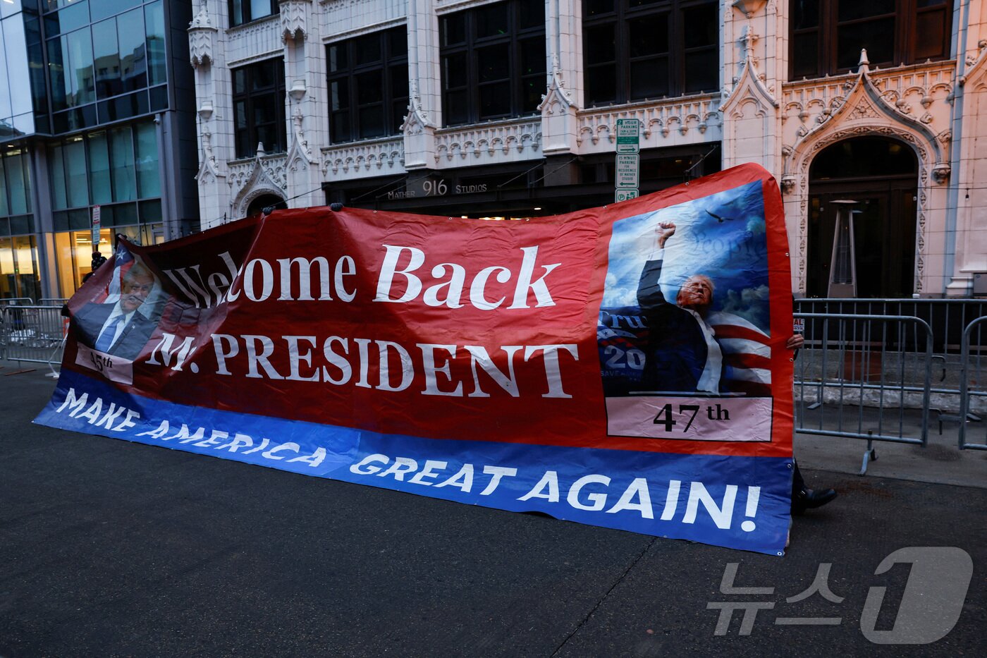 본문 이미지 - 도널드 트럼프 미국 대통령 지지자들이 19일&#40;현지시간&#41; &#39;캐피털원 아레나&#39;에서 열릴 승리 집회를 기다리면서 트럼프 대통령의 취임을 환영하는 현수막을 걸고 있다. ⓒ 로이터=뉴스1