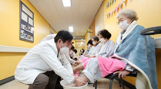 환자 발 씻겨주는 곽병원 의료진