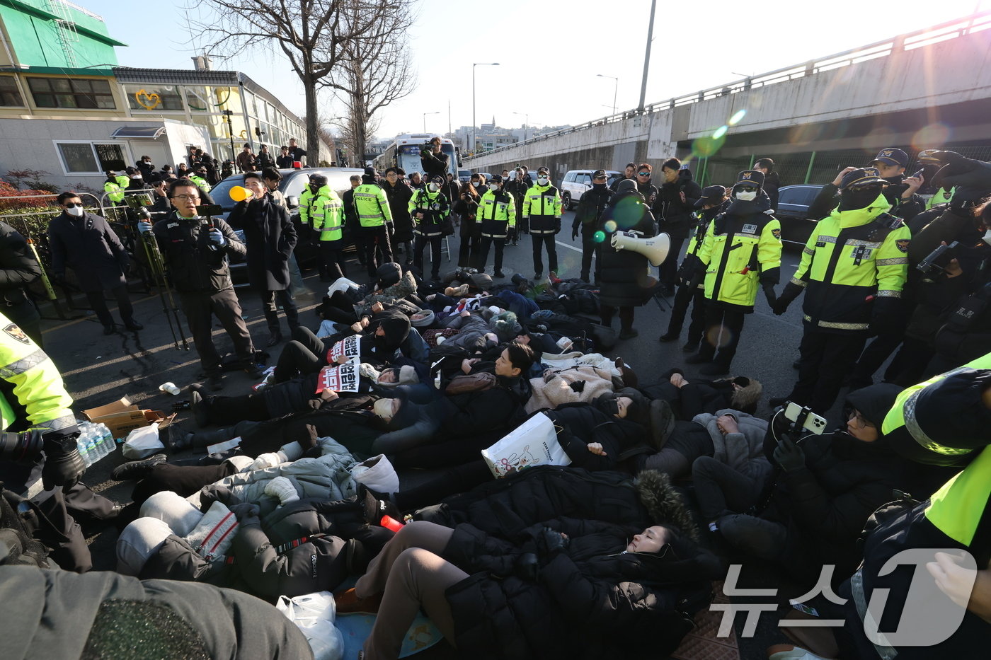 본문 이미지 - 2일 서울 용산구 윤석열 대통령 관저 입구 앞에서 보수단체 회원 및 윤 대통령 지지자들이 농성 중 해산하라는 경찰 안내방송에 드러눕고 있다.  2025.1.2/뉴스1 ⓒ News1 박세연 기자