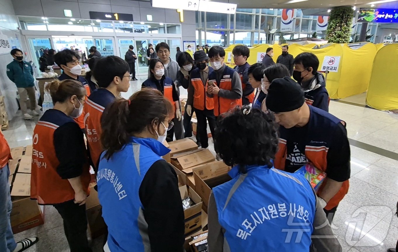 본문 이미지 - 현장 봉사자들이 BBQ 치킨 전달을 위해 논의하는 모습./이강 기자