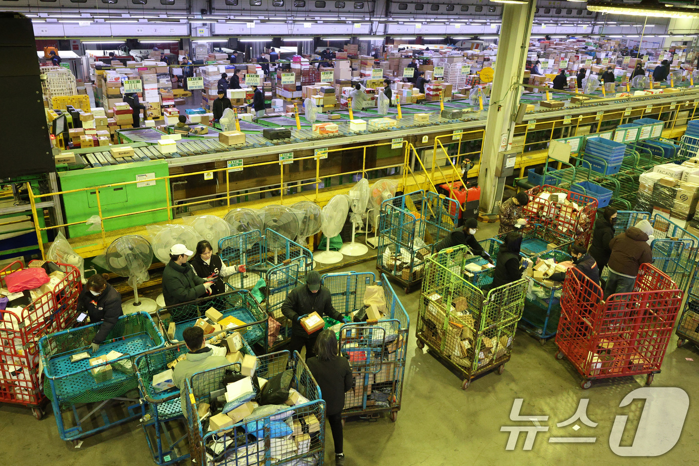(서울=뉴스1) 신웅수 기자 = 설 명절을 앞둔 21일 오전 서울 광진구 동서울우편물류센터에서 직원들이 택배 분류 작업으로 구슬땀을 흘리고 있다.우정사업본부는 설 연휴 기간 동안 …