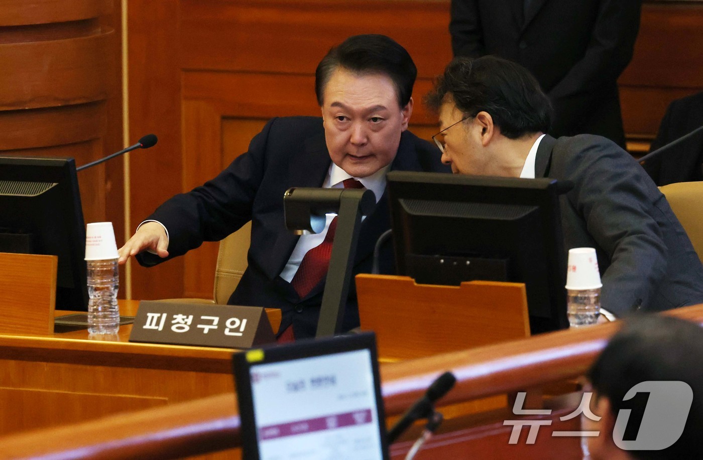 (서울=뉴스1) 사진공동취재단 = 윤석열 대통령이 21일 서울 종로구 헌법재판소에서 열린 탄핵심판 3차 변론기일에 출석, 차기환 변호사와 대화를 하고 있다. 2025.1.21/뉴스 …