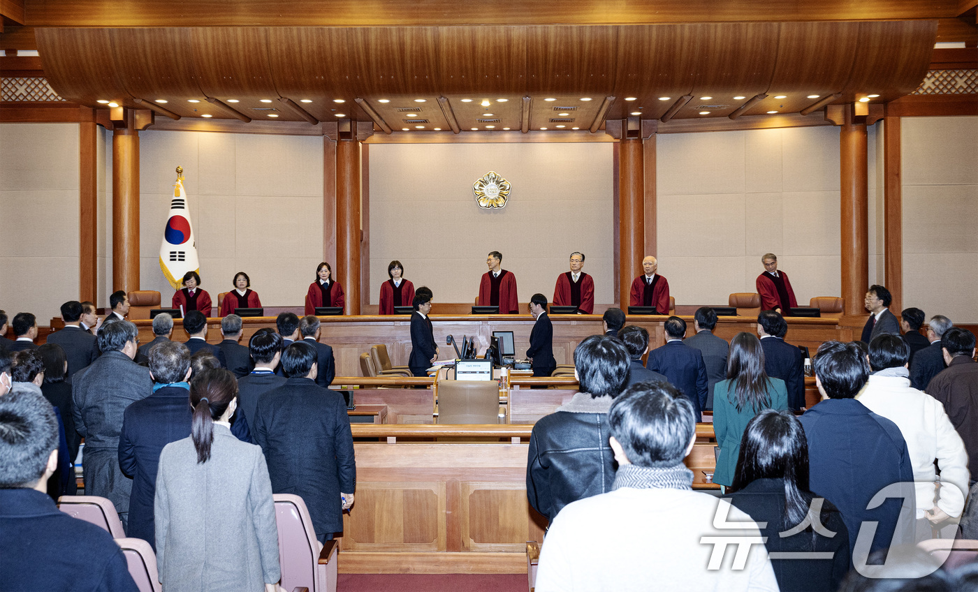 (서울=뉴스1) 사진공동취재단 = 21일 오후 서울 종로구 헌법재판소 대심판정에서 열린 윤석열 대통령 탄핵심판 3차 변론기일에서 헌법재판관들이 입장하자 참석자들이 기립하고 있다. …