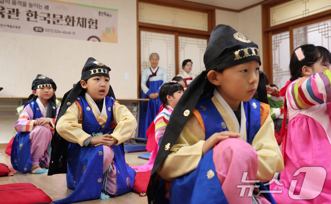 (용인=뉴스1) 김영운 기자 = 설 명절을 앞둔 22일 경기 용인시 처인구 용인시예절교육관에서 열린 '새해 맞이 설 명절 특강 및 체험'에서 다문화가정 참가자들이 세배를 배우고 있 …