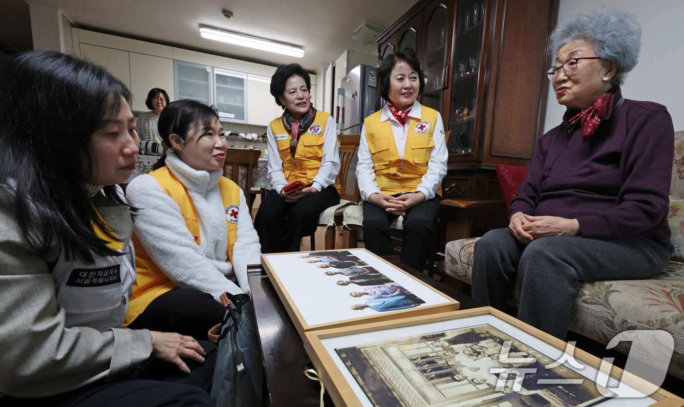 (서울=뉴스1) 장수영 기자 = 미상봉 이산가족 임화숙 어르신(92세)이 23일 오전 서울 은평구 자택에서 대한적십자사 봉사원들과 함께 가족사진 및 이산가족 AI 합성 사진을 보며 …