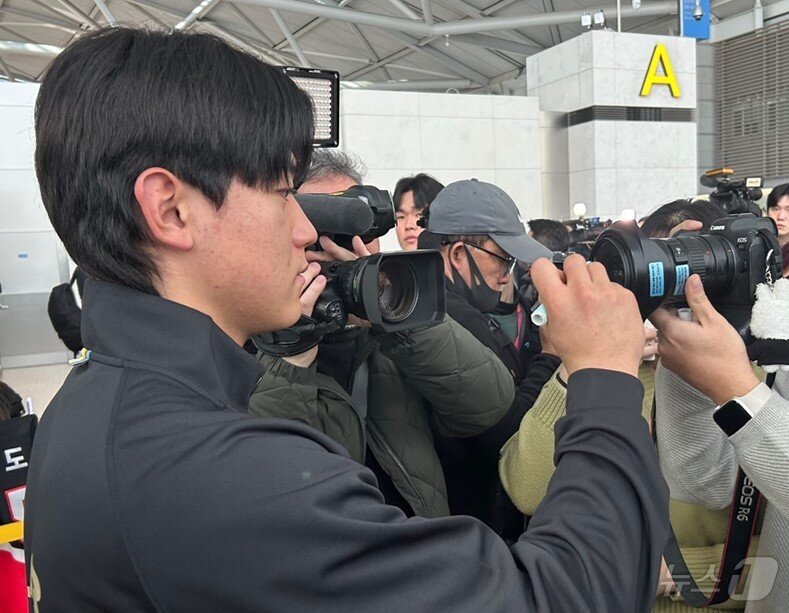 본문 이미지 -  23일 미국 스프링캠프 출국을 앞두고 인천공항에서 만난 KIA 타이거즈 내야수 김도영. 한 팬이 카메라 렌즈에 사인을 요청하자 성심성의껏 응했다. 2025.1.23/뉴스1 ⓒ News1 문대현 기자