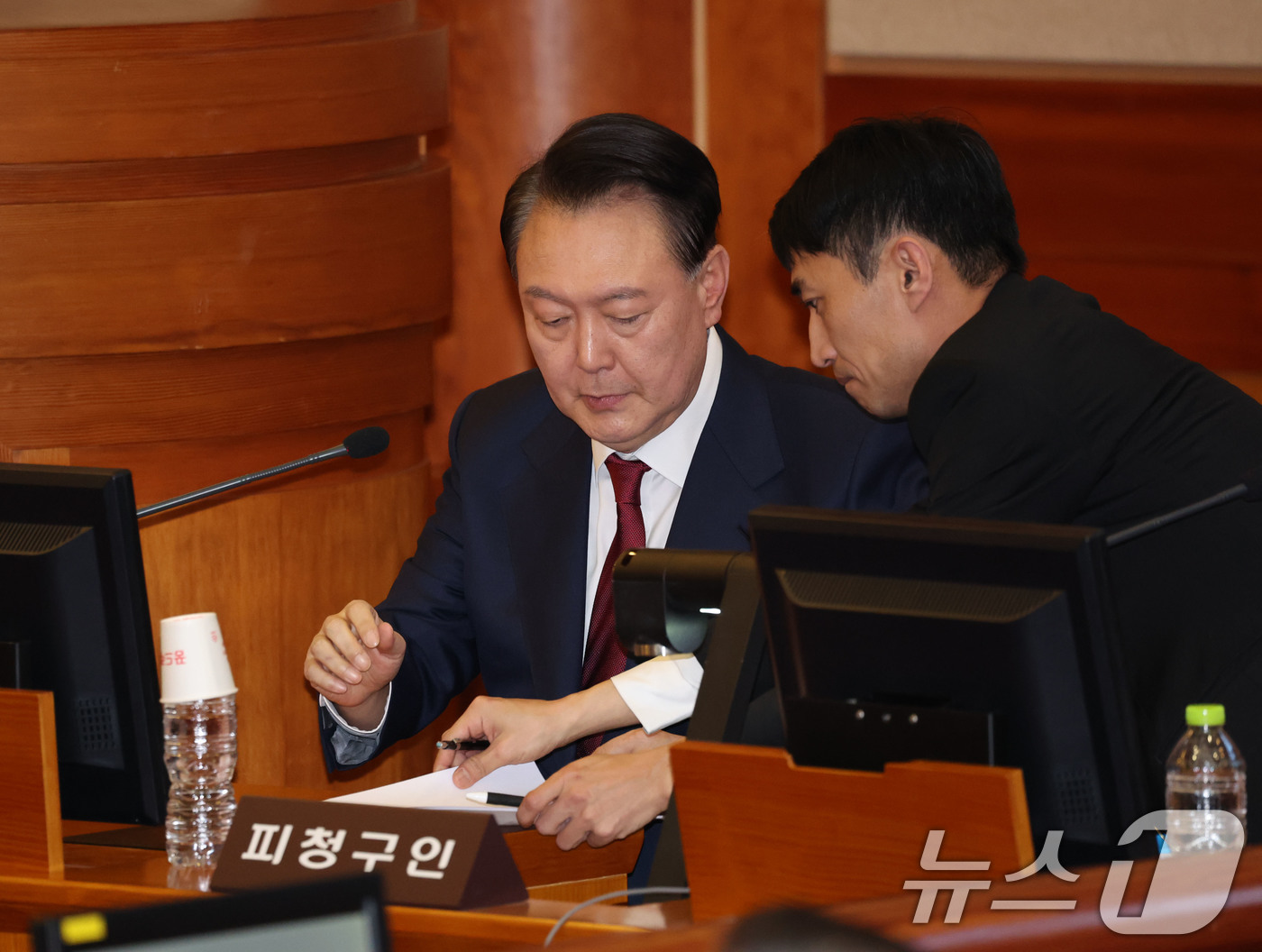 (서울=뉴스1) 사진공동취재단 = 윤석열 대통령이 23일 오후 서울 종로구 헌법재판소 대심판정에서 열린 탄핵심판 4차 변론기일에 출석해 메모지를 건네받고 있다. 2025.1.23/ …