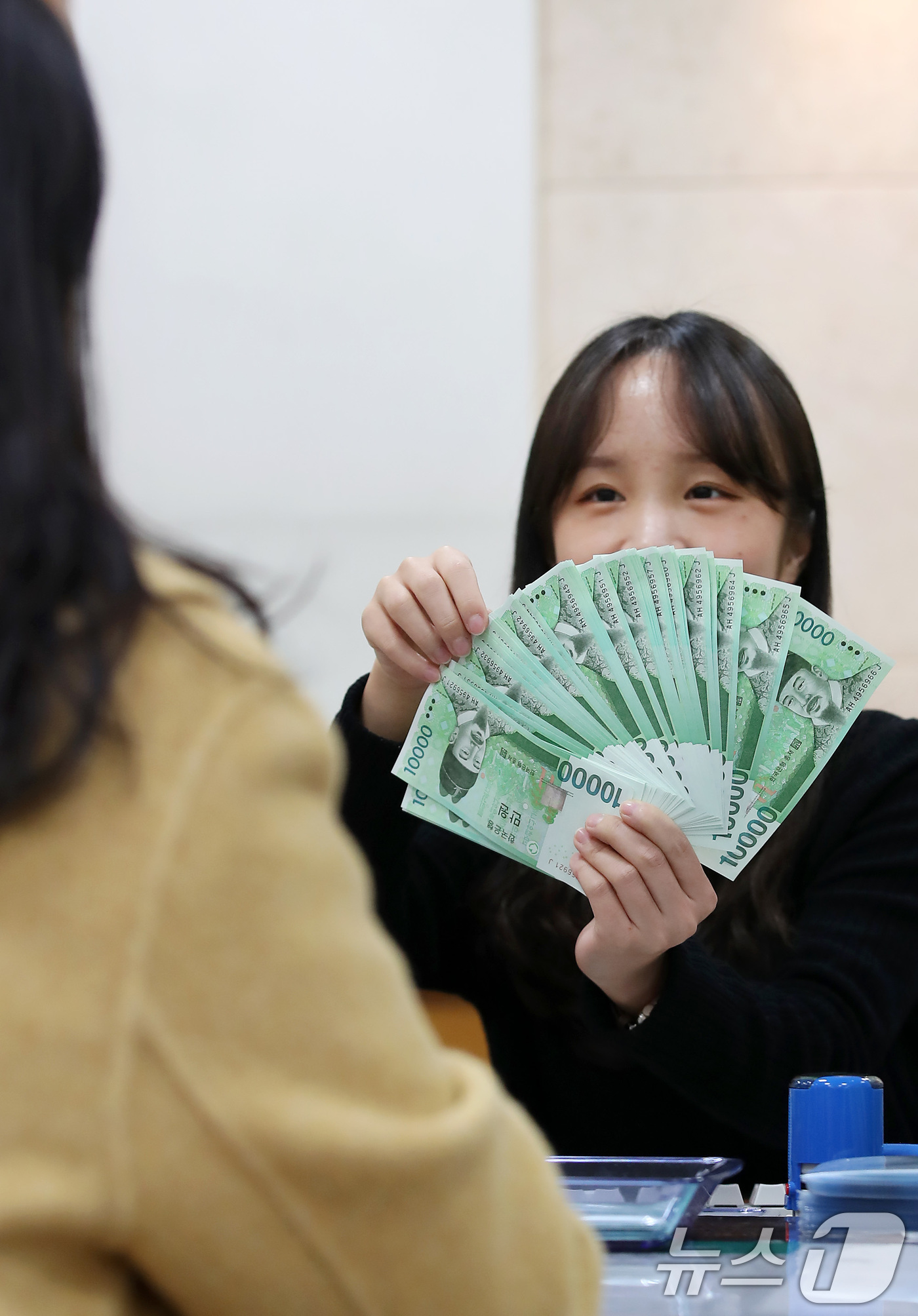 (대구=뉴스1) 공정식 기자 = 설 연휴를 이틀 앞둔 23일 오후 iM뱅크 대구 중구청지점에서 창구 직원이 세뱃돈을 준비하기 위해 찾아온 시민에게 신권을 교환해 주고 있다.오는 2 …