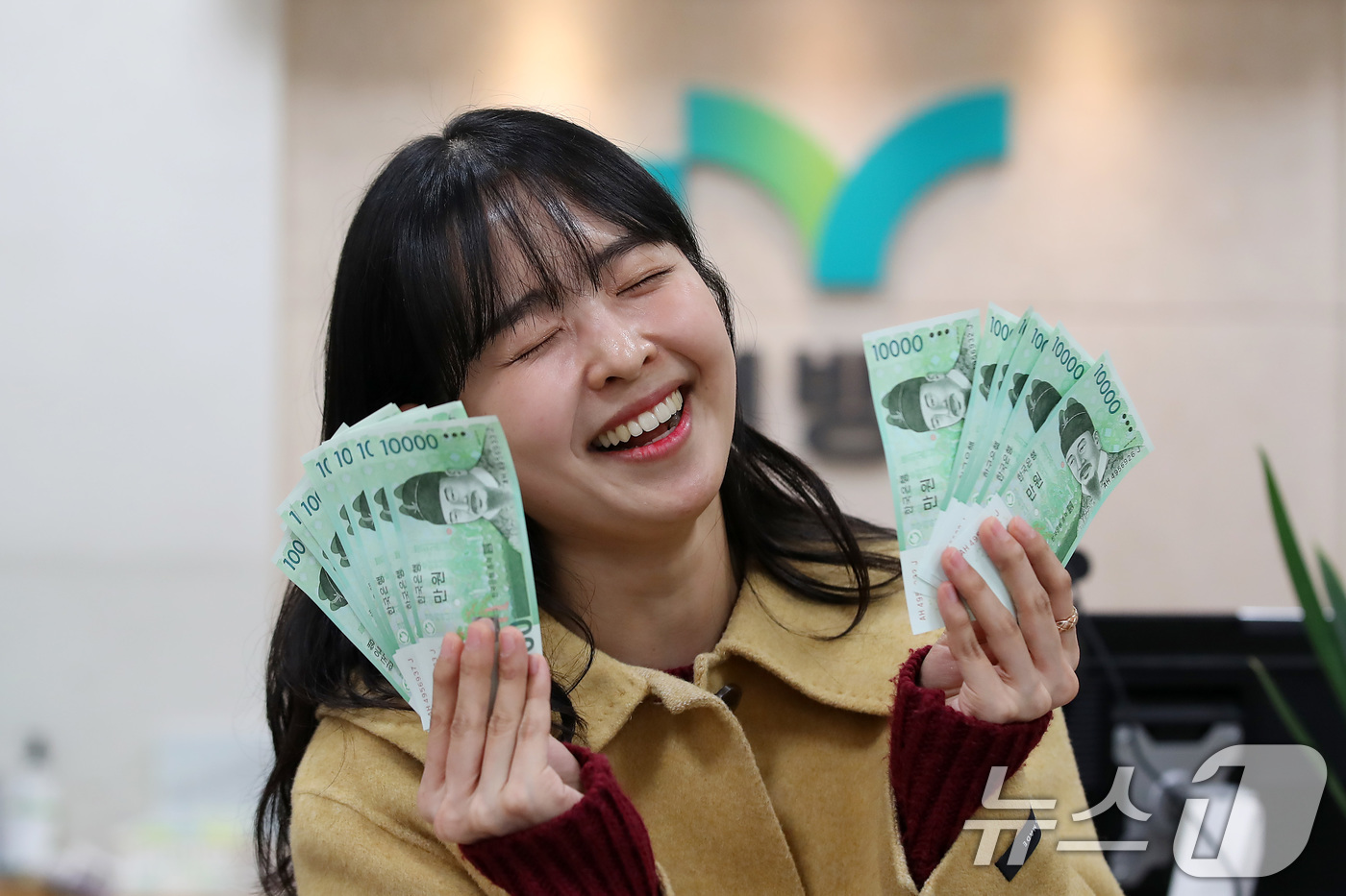 (대구=뉴스1) 공정식 기자 = 설 연휴를 이틀 앞둔 23일 오후 iM뱅크 대구 중구청지점에서 한 여성이 조카들에게 줄 세뱃돈을 신권으로 교환한 뒤 환하게 웃고 있다.오는 27일 …