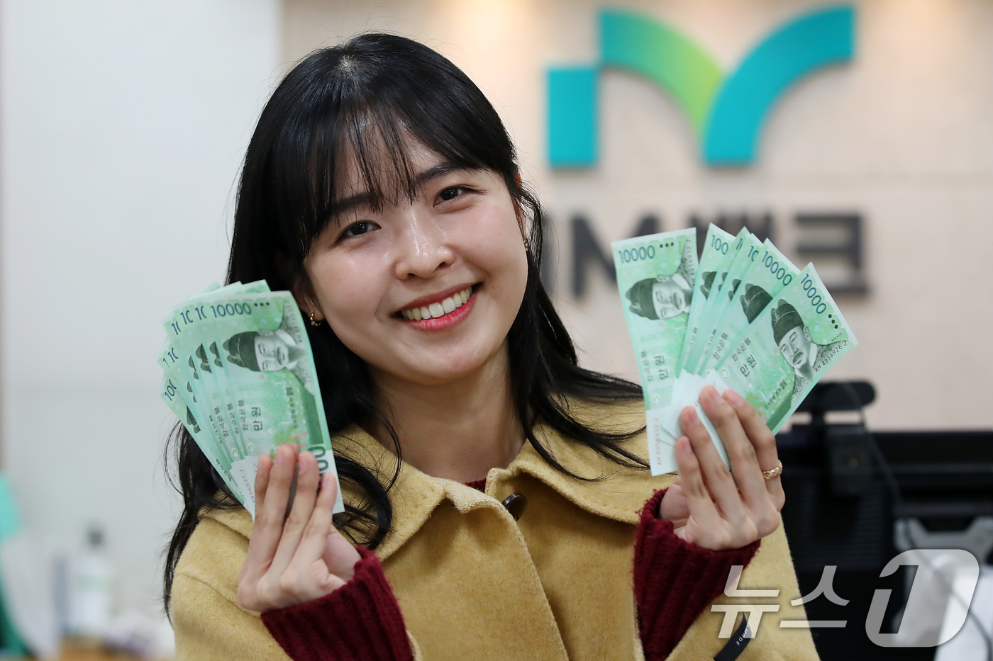 (대구=뉴스1) 공정식 기자 = 설 연휴를 이틀 앞둔 23일 오후 iM뱅크 대구 중구청지점에서 한 여성이 조카들에게 줄 세뱃돈을 신권으로 교환한 뒤 환하게 웃고 있다.오는 27일 …