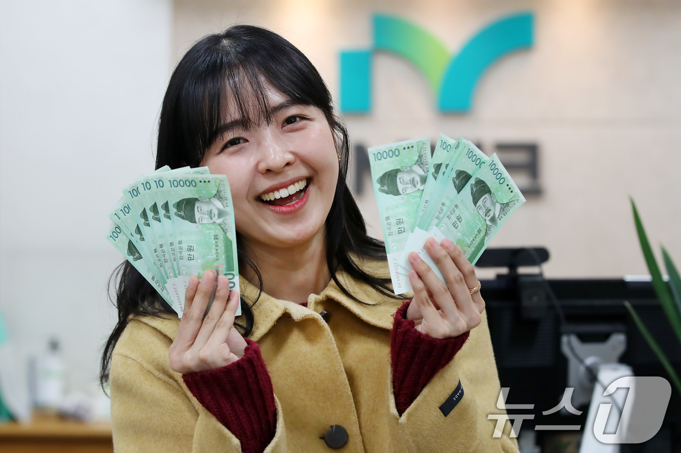 (대구=뉴스1) 공정식 기자 = 설 연휴를 이틀 앞둔 23일 오후 iM뱅크 대구 중구청지점에서 한 여성이 조카들에게 줄 세뱃돈을 신권으로 교환한 뒤 환하게 웃고 있다.오는 27일 …