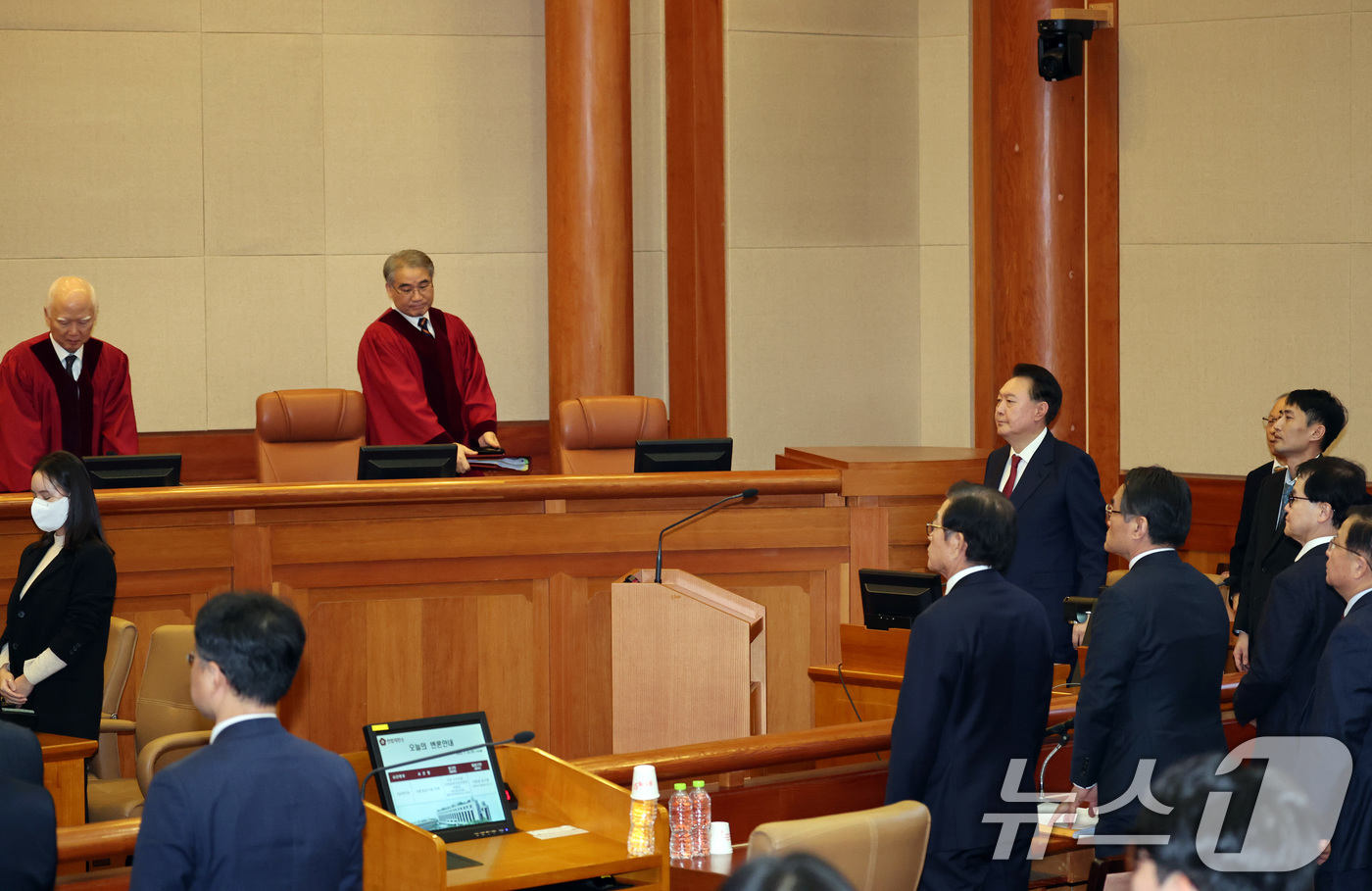 (서울=뉴스1) 사진공동취재단 = 윤석열 대통령이 23일 오후 서울 종로구 헌법재판소 대심판정에서 열린 탄핵심판 4차 변론기일에 출석해 헌법재판관들이 입장하자 일어서고 있다. 20 …