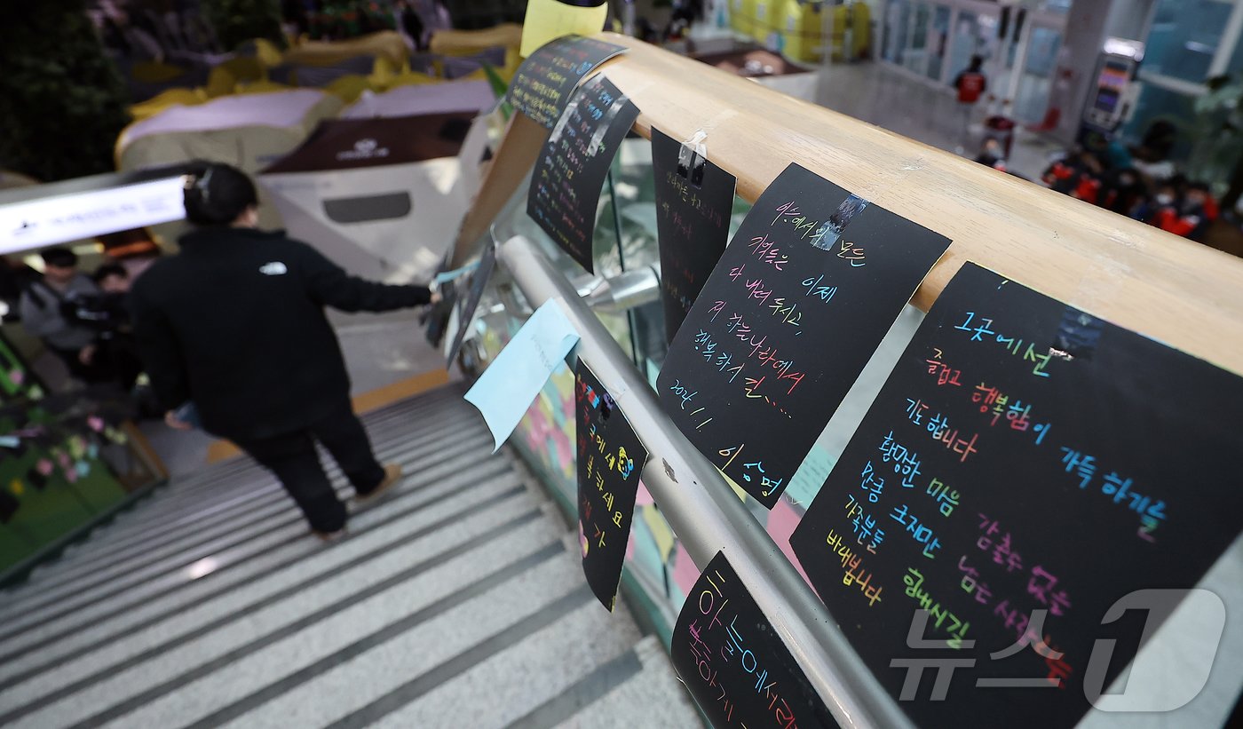 본문 이미지 - 제주항공 여객기 참사 엿새째인 3일 전남 무안군 무안국제공항 대합실 계단에서 한 유가족이 희생자를 추모하는 글귀를 바라보고 있다. 2025.1.3/뉴스1 ⓒ News1 김진환 기자