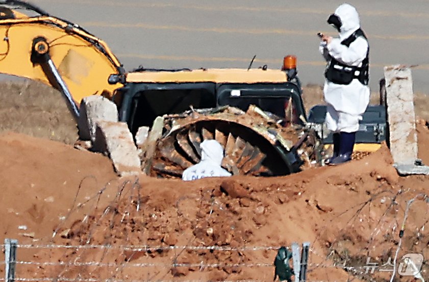 본문 이미지 - 제주항공 여객기 참사 엿새째인 3일 오후 전남 무안국제공항 참사 현장에서 국과수 관계자들이 로컬라이저(방위각시설) 둔덕에 파묻힌 엔진을 살펴보고 있다. 2025.1.3/뉴스1 ⓒ News1 오대일 기자