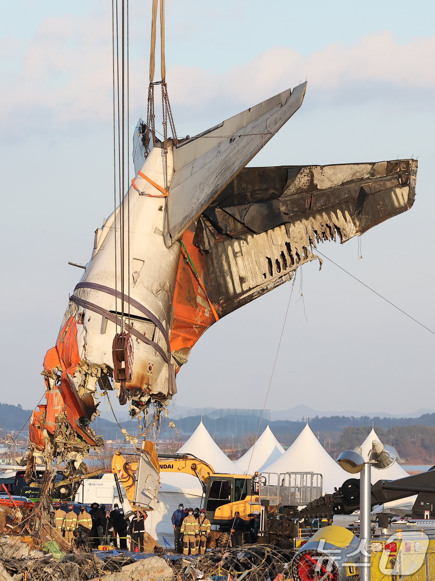 본문 이미지 - 제주항공 여객기 참사 엿새째인 3일 오후 전남 무안국제공항 참사 현장에서 사고 기체의 꼬리 부분이 타워크레인에 의해 인양되고 있다. 2025.1.3/뉴스1 ⓒ News1 김진환 기자