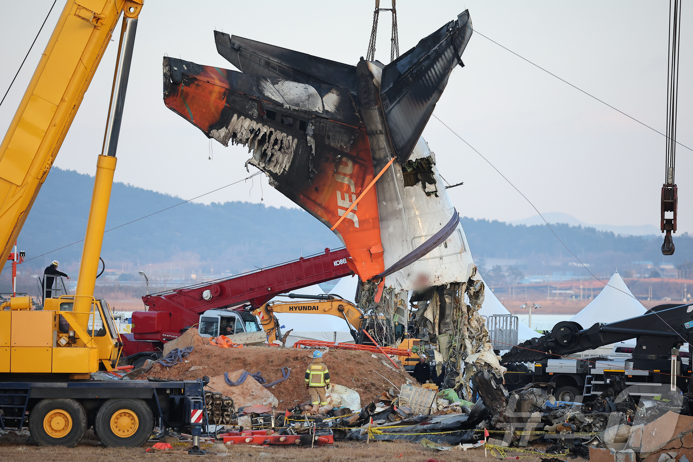 (무안=뉴스1) 김진환 기자 = 제주항공 여객기 참사 엿새째인 3일 오후 전남 무안국제공항 참사 현장에서 사고 기체의 꼬리 부분이 타워크레인에 의해 인양되고 있다. 2025.1.3 …