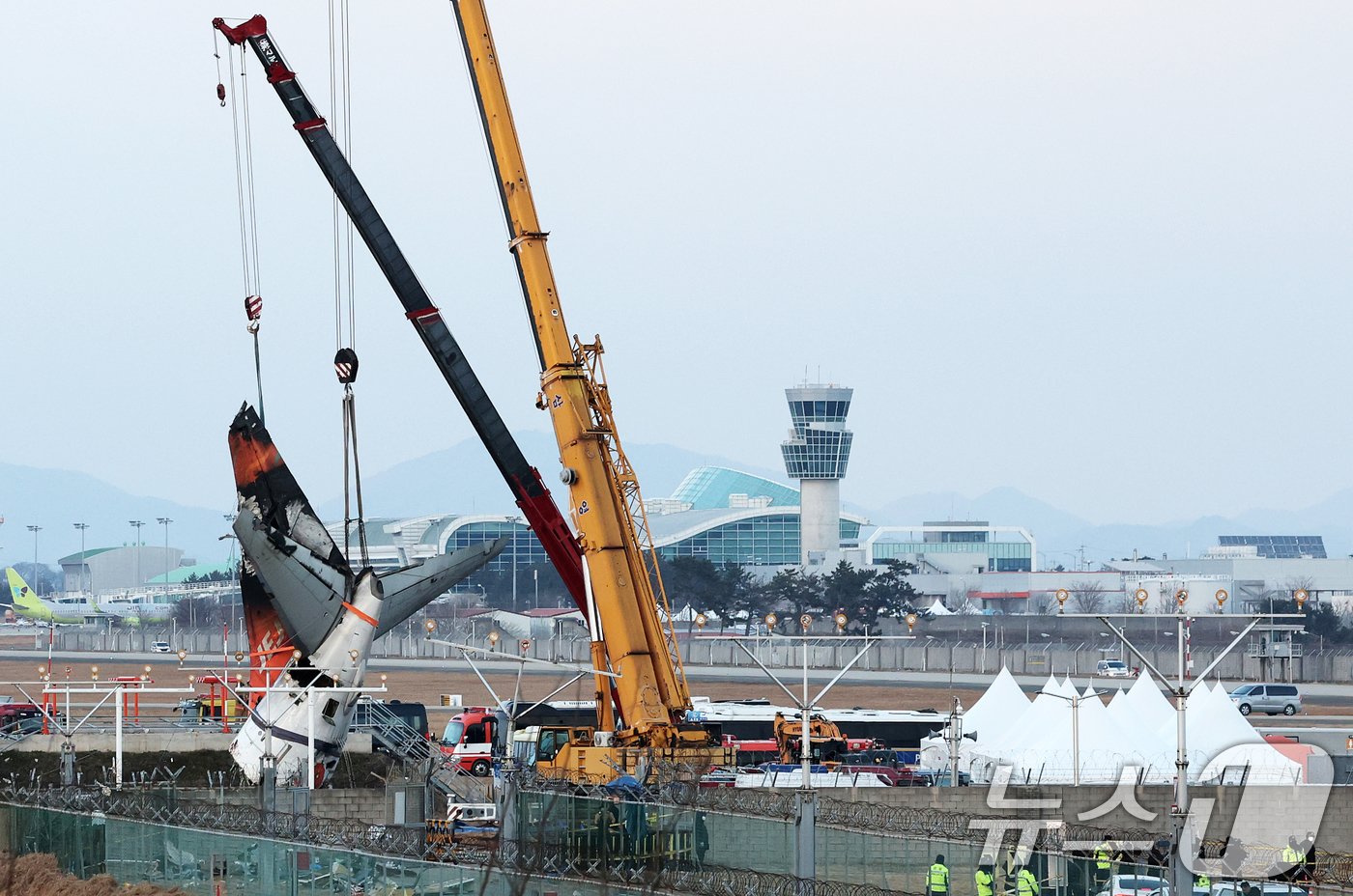 본문 이미지 - 제주항공 여객기 참사 엿새째인 3일 오후 전남 무안국제공항 참사 현장에서 제주항공 7C2216편 사고 기체의 꼬리 부분이 크레인에 의해 인양되고 있다. 2025.1.3/뉴스1 ⓒ News1 오대일 기자