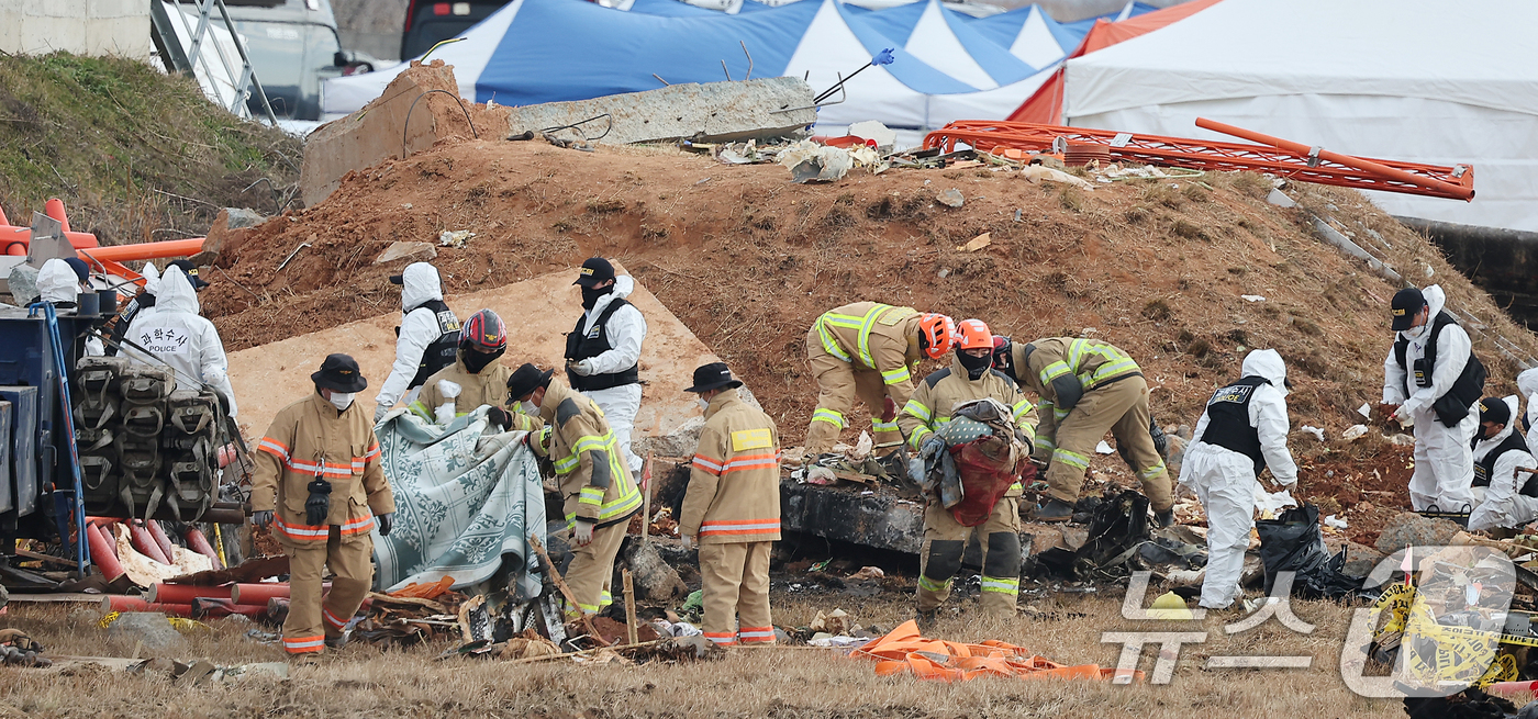 (무안=뉴스1) 김진환 기자 = 제주항공 여객기 참사 7일째인 4일 전남 무안군 무안국제공항 참사 현장에서 경찰 과학수사대와 소방대원들이 방위각시설(로컬라이저) 일대 수색 및 현장 …