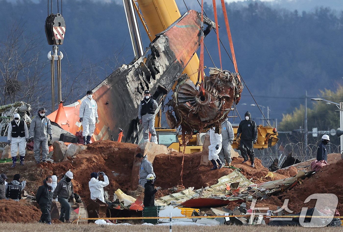 본문 이미지 - 제주항공 여객기 참사 7일째인 4일 오후 전남 무안국제공항 참사 현장에서 로컬라이저&#40;방위각시설&#41; 둔덕에 파묻힌 제주항공 7C2216편의 엔진이 크레인으로 옮겨지고 있다. 2025.1.4/뉴스1 ⓒ News1 김진환 기자