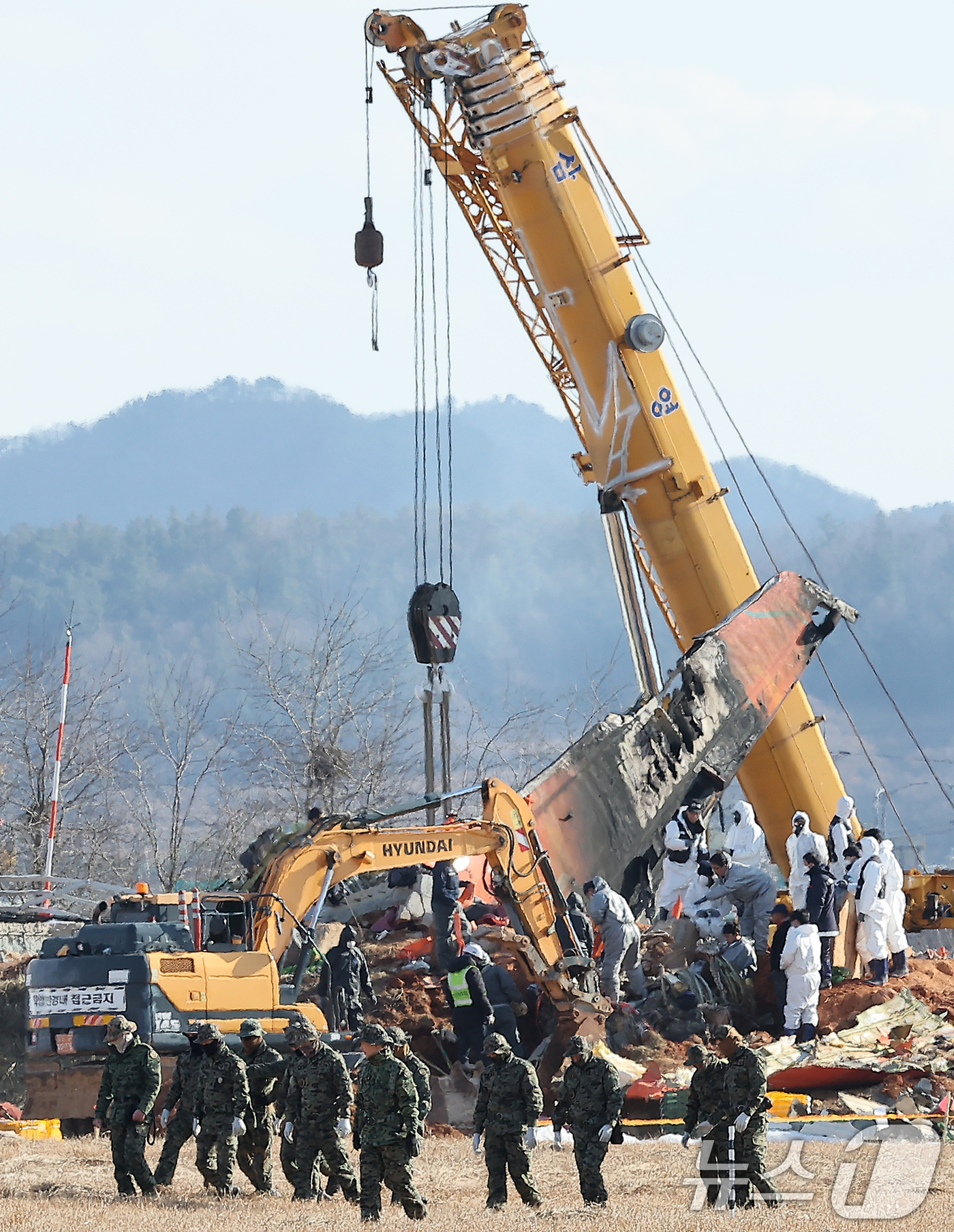 (무안=뉴스1) 김진환 기자 = 제주항공 여객기 참사 7일째인 4일 오후 전남 무안국제공항 참사 현장에서 특전사 대원들의 수색 작업 뒤로 방위각시설(로컬라이저)에서 엔진 인양 작업 …